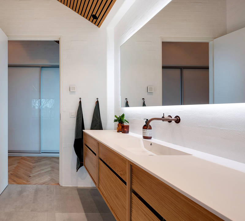 Snickartillverkat badrum från uno form i Copenhagen design i ek med vit Corian-skiva och handfat.