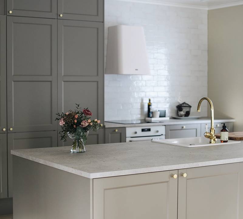 Ovimalli on Keittiömaailman Eerika, 61P, väri Luonto-värikokoelman Tähkä (Taupe)
Työtaso: vaalea Terrazzo, laminaatti.
Liesituuletin on Franke SMART DECO liesituuletin.
Franken valkoinen keraaminen pesuallas ja siihen yhdistettynä Damixan kirkas messinkinen hana.