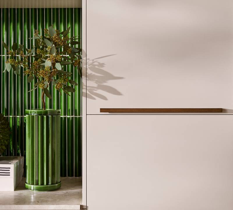 Nærbillede av benk og højskabe Athena Sand med massiv tre håntdag og grønne fliser bak