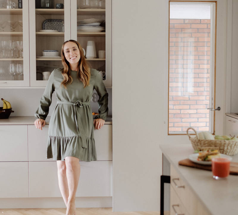 Anni Ihamäki toimivassa melamiini- ja laminaattikeittiössä Hiekassa ja lämminsävyinen vaalea tammimelamiini Novartilta, vitriinikaapeilla ja Quartz-tasolla