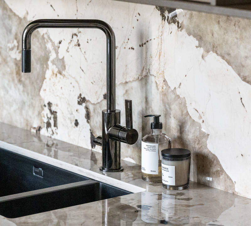 Svart diskho och mörk blandare i köket Arkitekt Plus Sand och Signatur Ekbacken fanerad eklucka i brunbets från Marbodal, med matchande bänkskiva och stänkskydd.