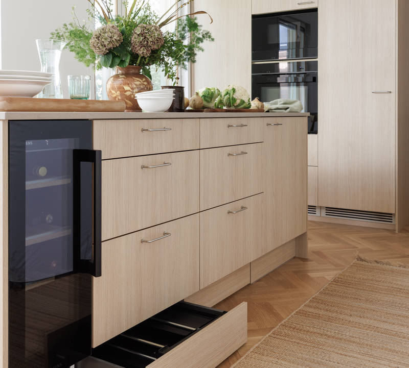 Aitoa luonnontammea Novartilta, yhdistelmä yhteensopivia puisia ja painonappikahvoja, keittiösaareke hanalla, tiskiallas ja ruostumattomasta teräksestä valmistettu työtaso.