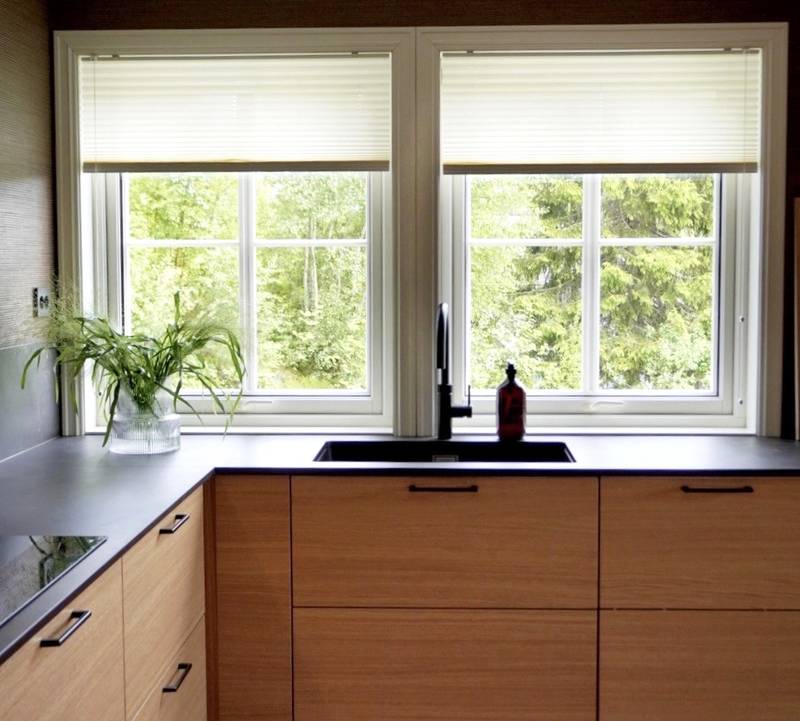 Modern eikekjøkken Amfi Natur fra Sigdal med sort marmor Dekton benkeplate og sorte håndtag.