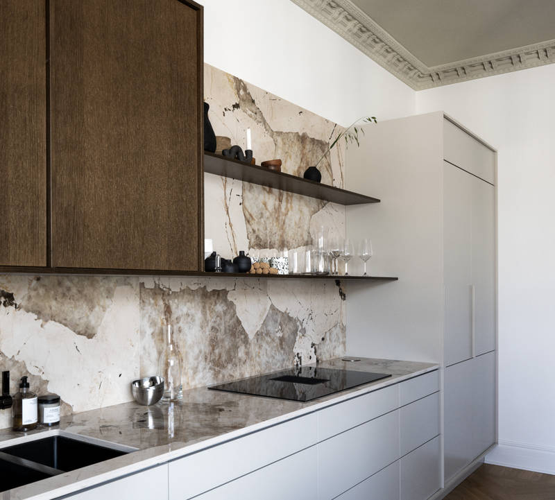 Køkken med en kombination af køkkenbænk i beige Athena Sand med overskabe og højskabe i Forever Oak fineret egetræslåge i brunbejdset fra INVITA, bordplade og stænkplade der matcher og åbne væghylder i brunbejdset eg finer.