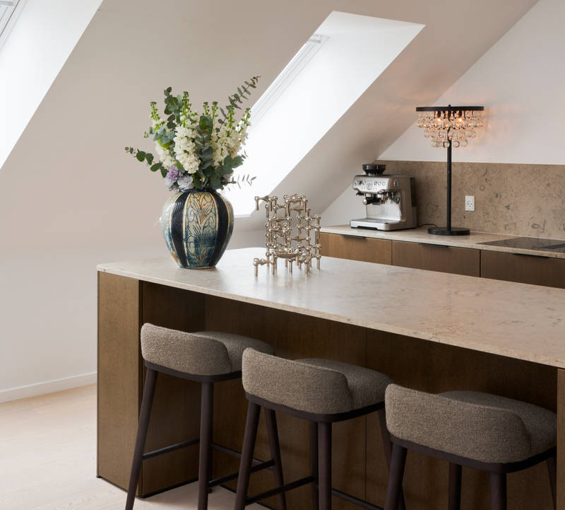 Signatur Ekbacken-kök med köksö, mörka träfronter, bänkskiva och stänkskydd i marmor, svart handfat och mässingsblandare