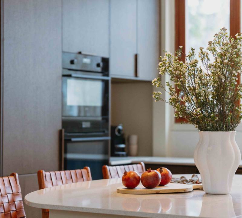 Eikekjøkkenet Favn fra Sigdal i beisfargen Nøtt kjøkkenøy og ovner i høyskaber, matchende tre håndtag, med benkeplate Blanco City fra Silestone.