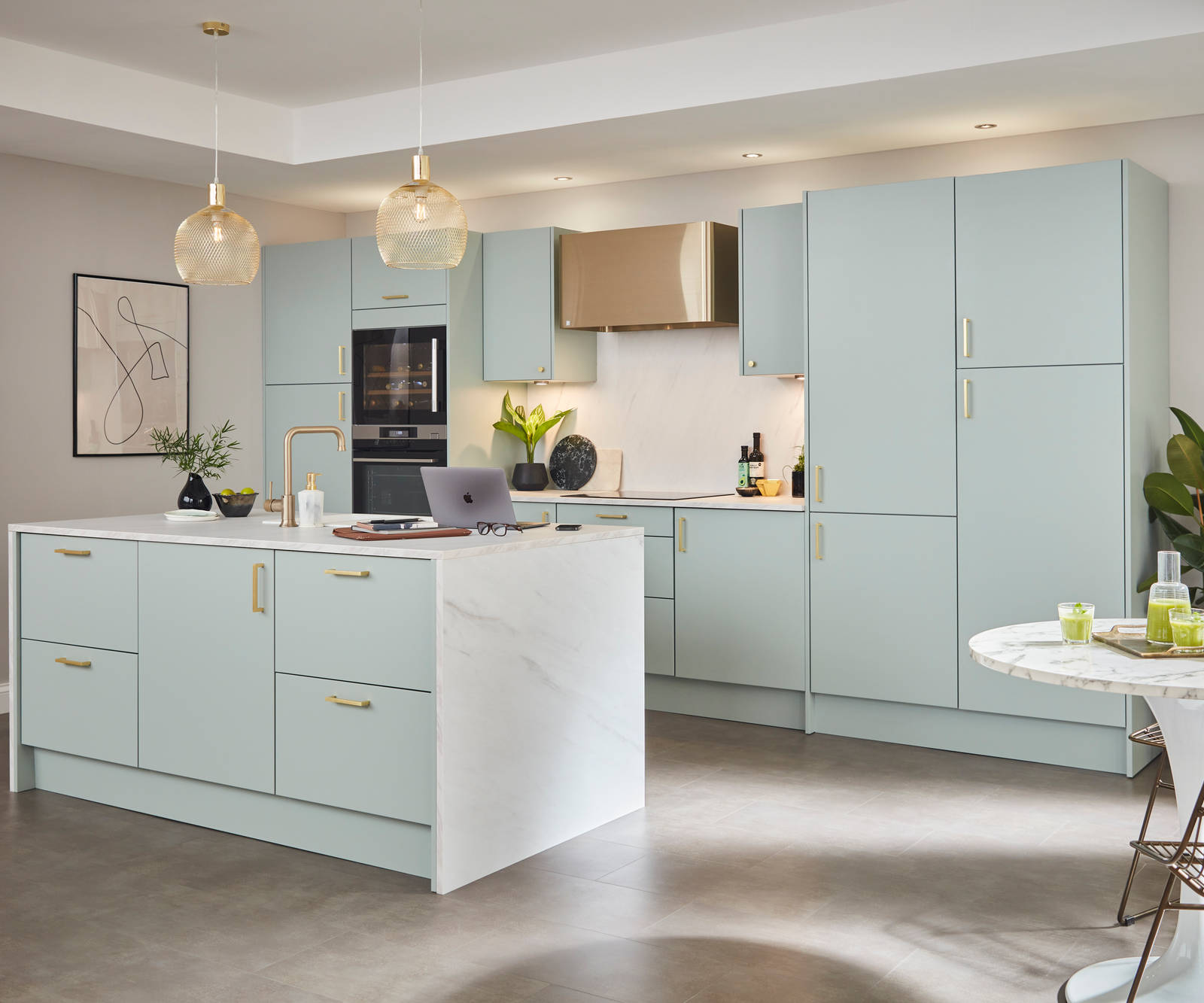 Light open plan Soho kitchen in Seagrass shade with brass tap, handles and other accent details