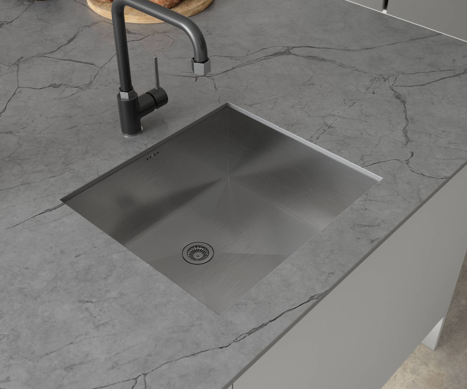 Overhead vire of matt black tap and square sink on grey Integra Nova kitchen island with marbled grey worktop.