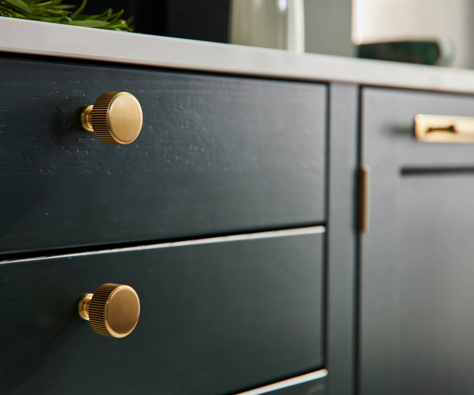 Ludlow, a traditional Shaker-style kitchen range in the shade Arboretum Green, combined with brass handles and knobs.
