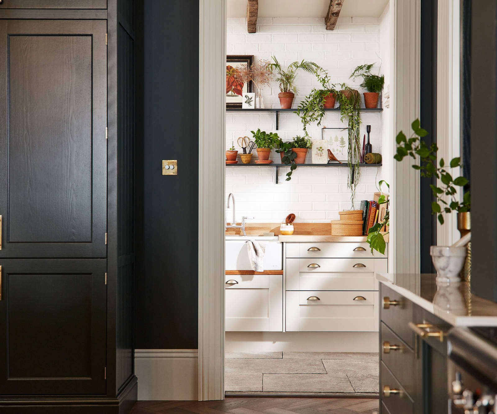 Ludlow, a traditional Shaker-style kitchen range in the shade Arboretum Green combined with a white utility room next door.