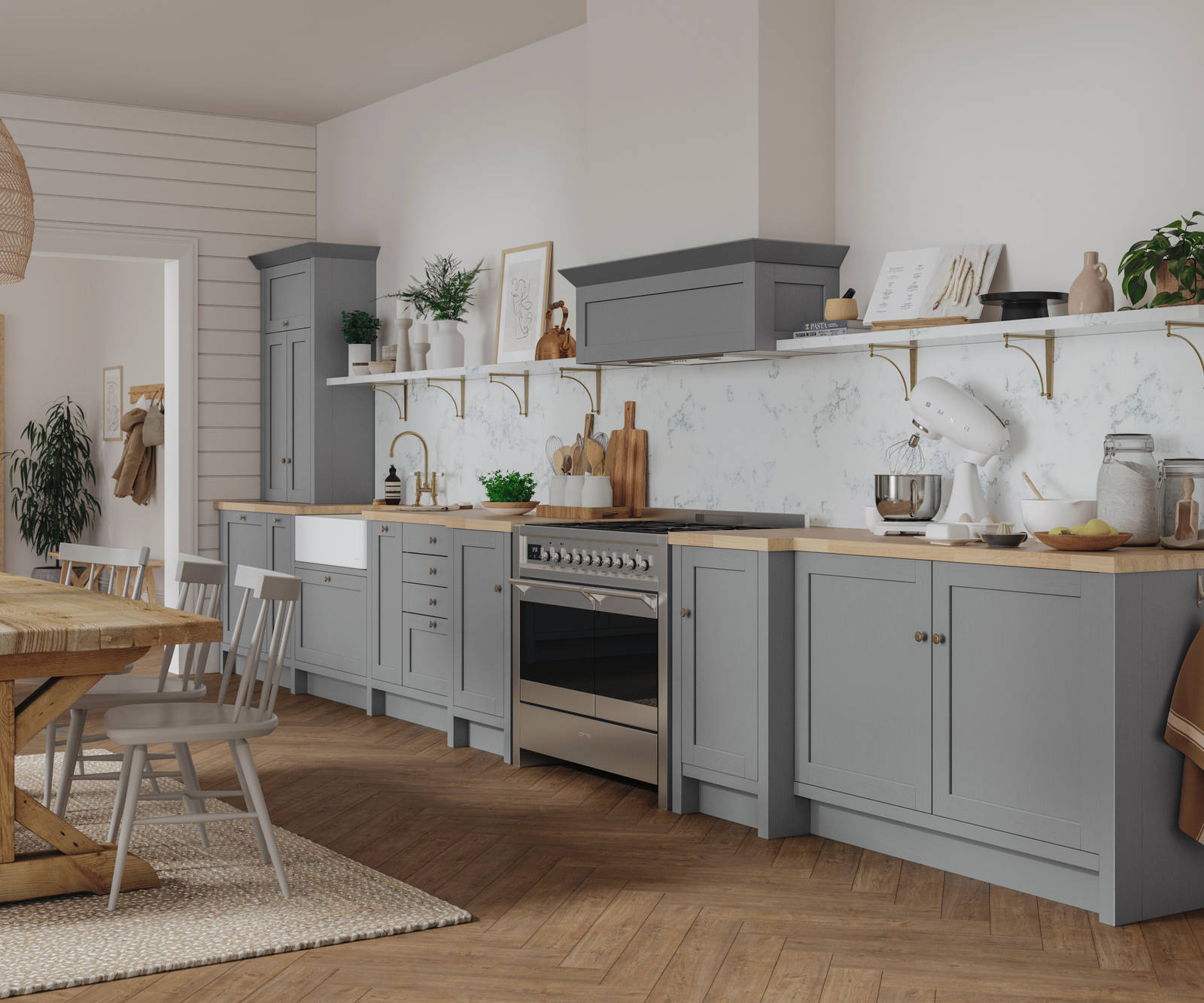 A grey Shaker kitchen seen with a wooden dining table and accessorised with plants.