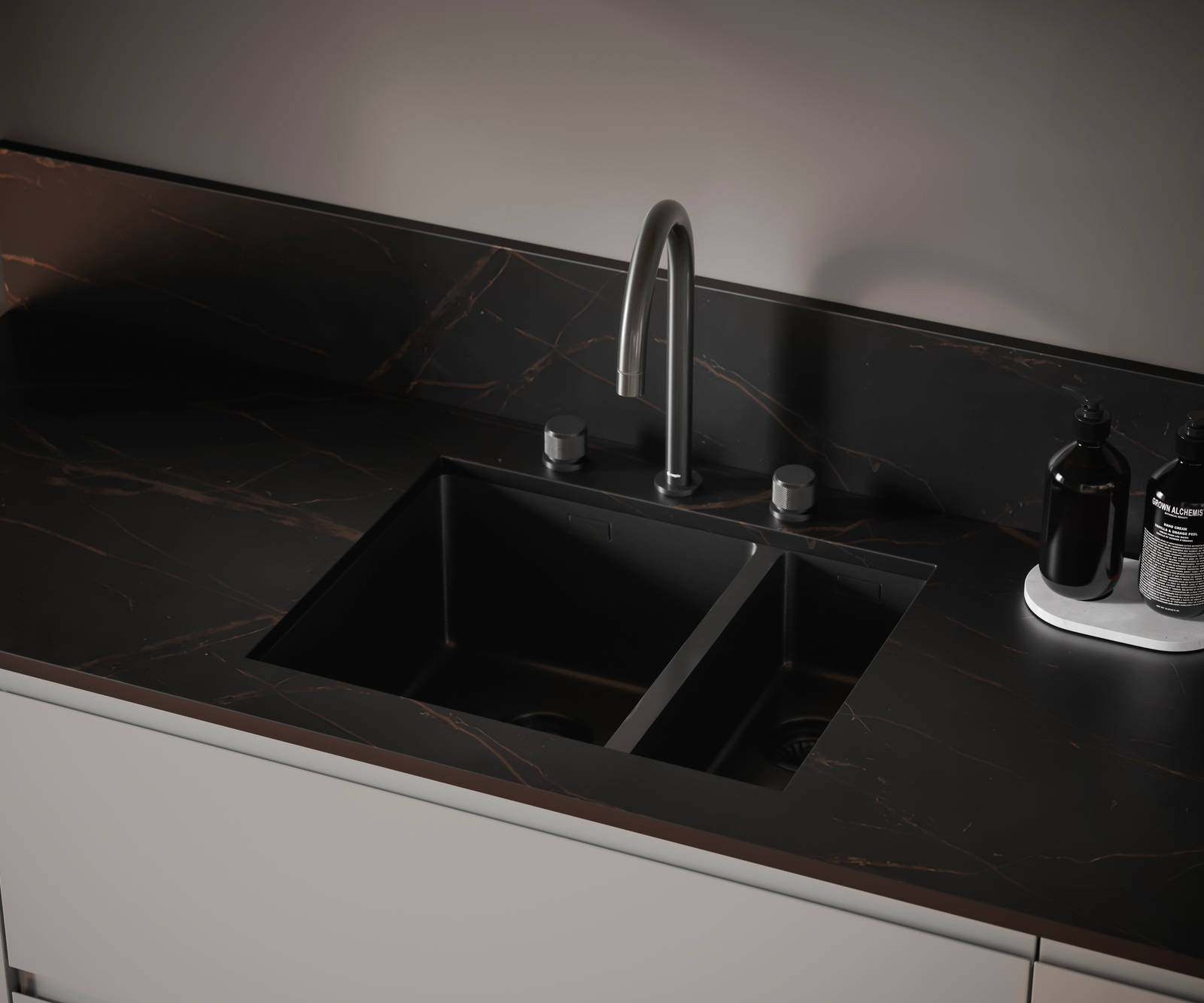 The J-pull handle of Magnet's Duxbury kitchen range is seen with a dark kitchen worktop and modern integrated double sink and arched tap.