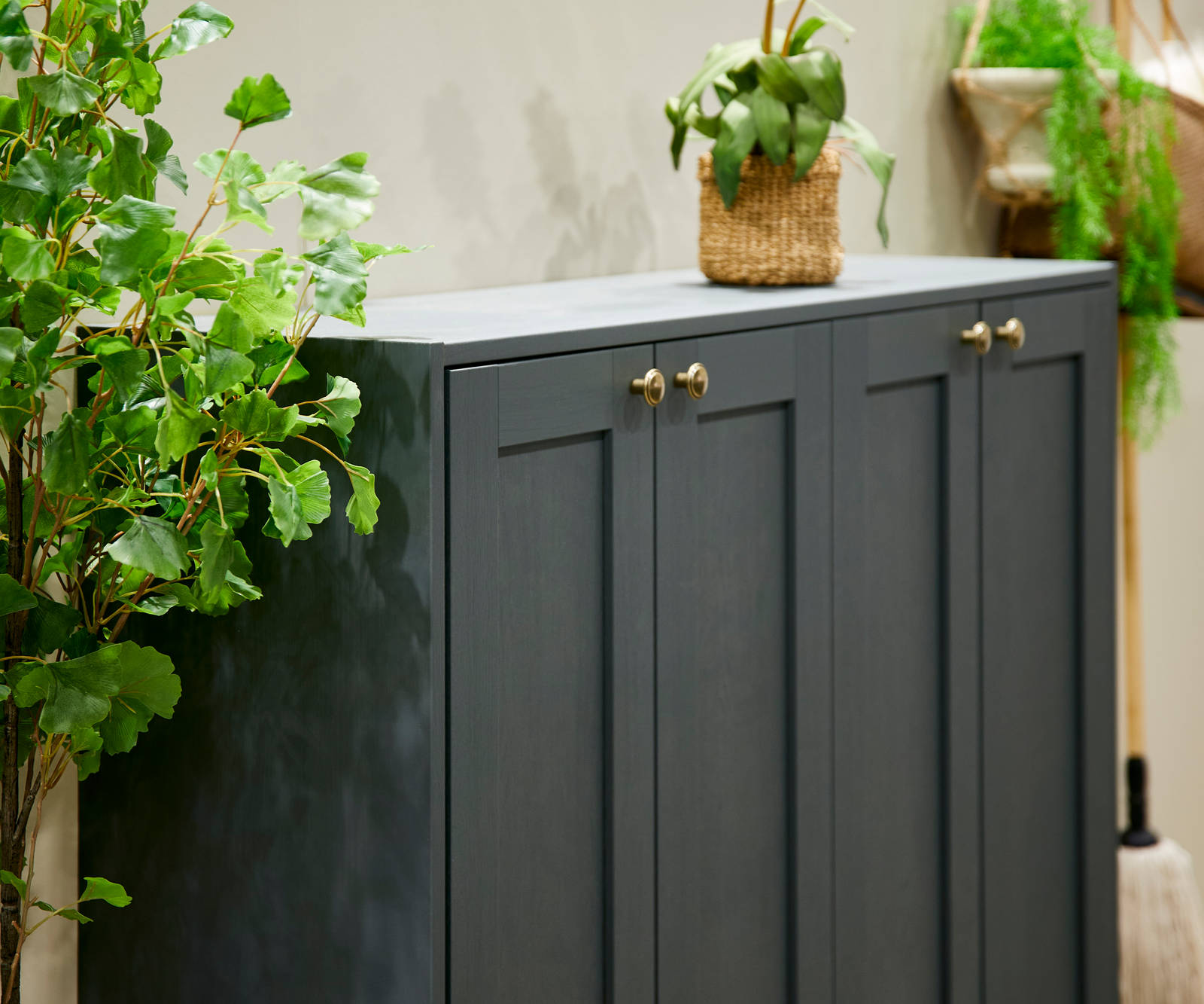 The Ambleside kitchen range in Fern, a dark shade of green, paired with brass handles.