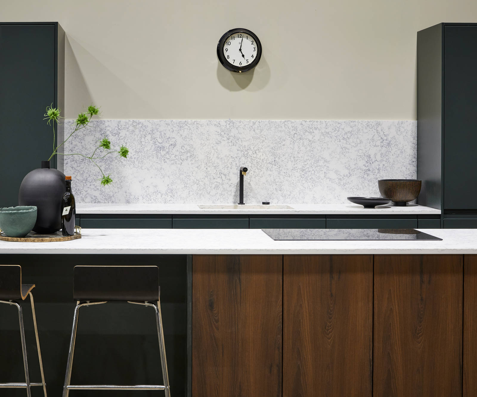 The modern Duxbury kitchen in Arboretum, paired with a wood-effect kitchen island, white worktop and splashback and accessorised with natural accents.