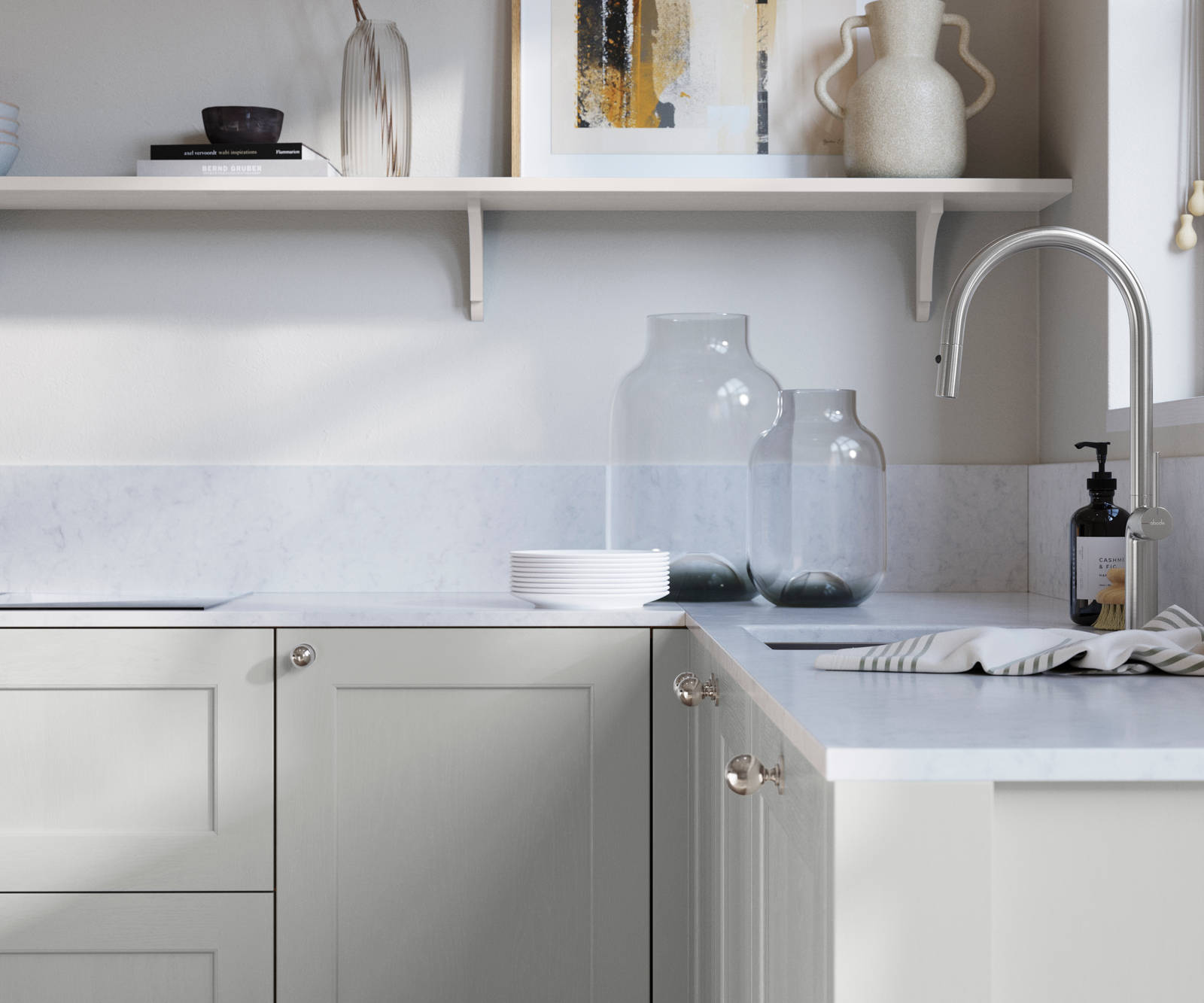 Ludlow, a traditional Shaker-style premium feel kitchen range with a visible woodgrain on its panelled doors here shown in the light shade Washed cotton styled with steel knobs, steel tap, a white marbled worktop with matching splashback.