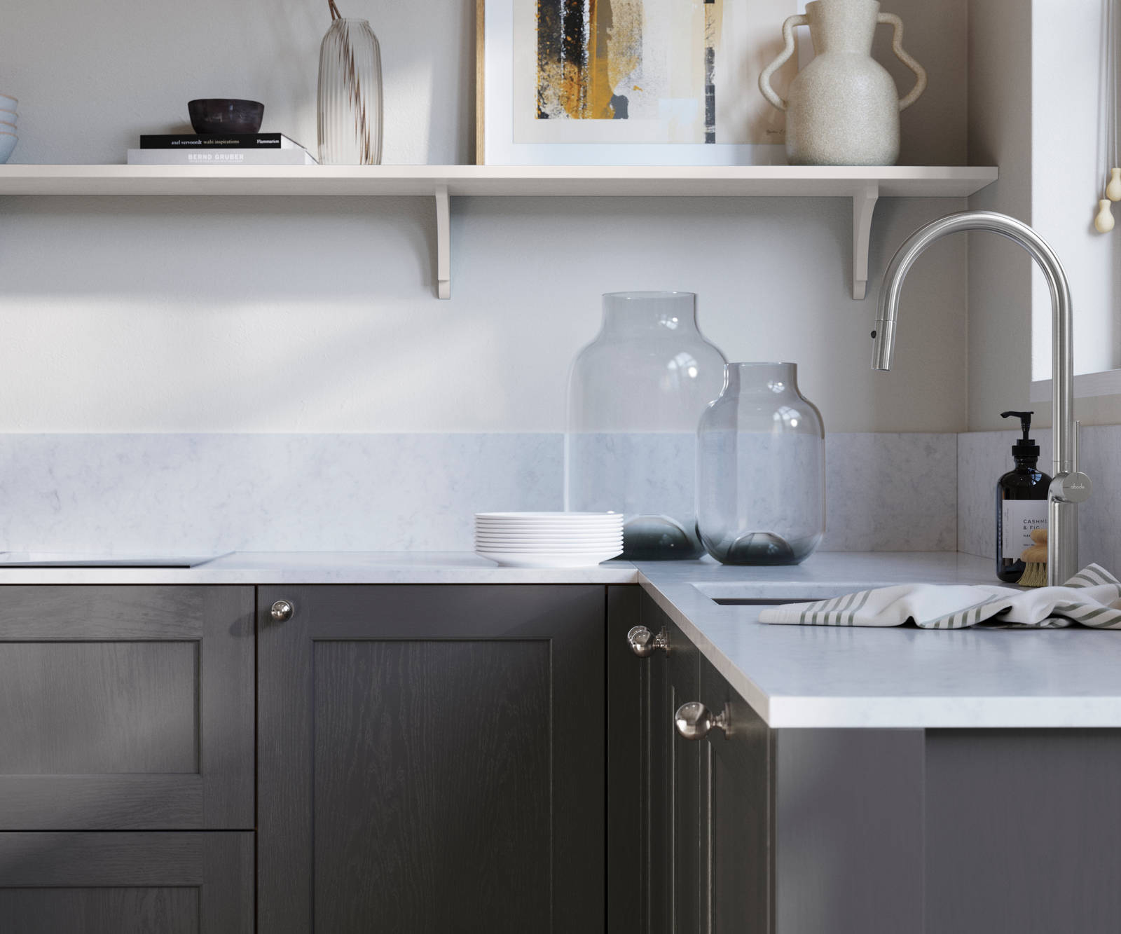 Ludlow, a traditional Shaker-style premium feel kitchen range with a visible woodgrain on its panelled doors here shown in the dark grey shade Charcoals styled with steel knobs, steel tap, a white marbled worktop with matching splashback.