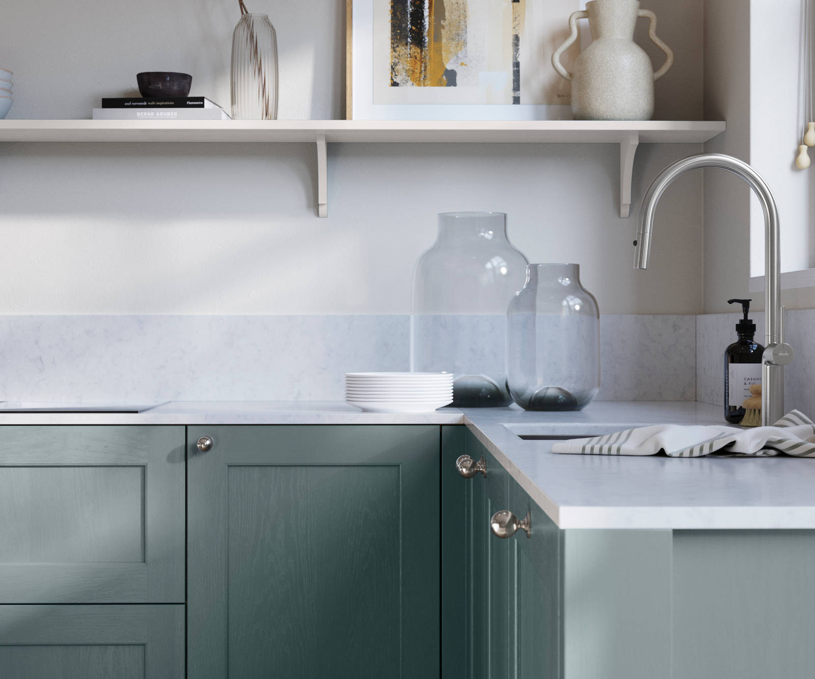 Ludlow, a traditional Shaker-style premium feel kitchen range with a visible woodgrain on its panelled doors here shown in the light shade Coastland styled with steel knobs, steel tap, a white marbled worktop with matching splashback.