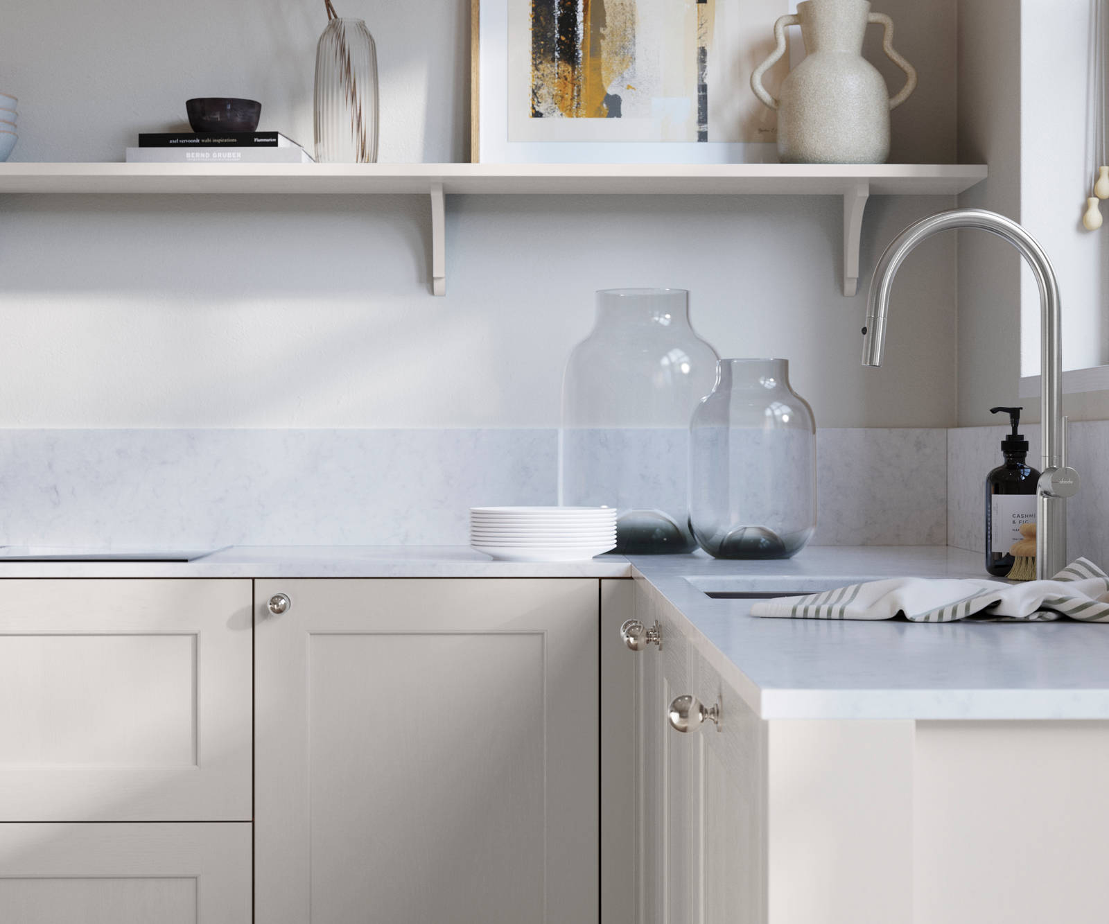 Ludlow, a traditional Shaker-style premium feel kitchen range with a visible woodgrain on its panelled doors here shown in the light shade Fresh Linen styled with steel knobs, steel tap, a white marbled worktop with matching splashback.