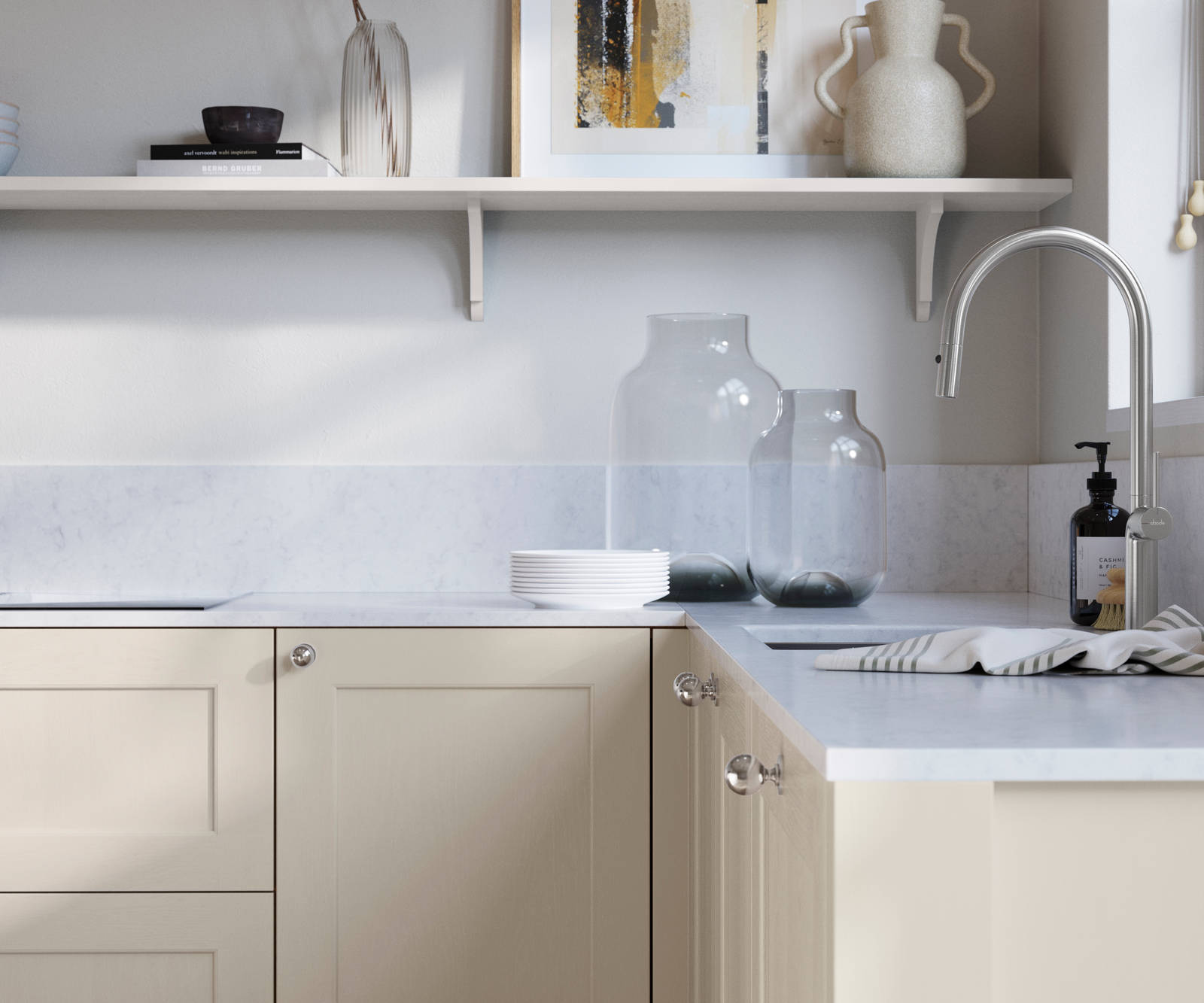 Ludlow, a traditional Shaker-style premium feel kitchen range with a visible woodgrain on its panelled doors here shown in the light shade limestone styled with steel knobs, steel tap, a white marbled worktop with matching splashback.
