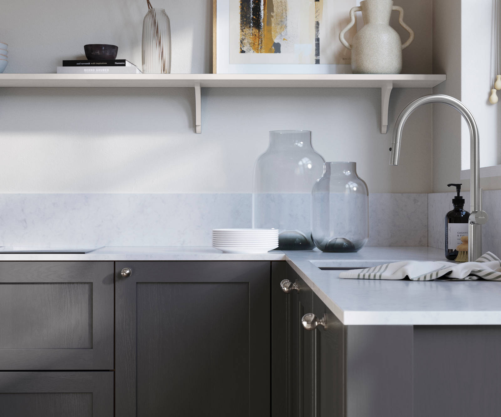 Wardley Charcoals kitchen cabinetry with steel knobs, steel tap, white marbled worktop and matching backsplash. An open shelf on the wall above cabinets with ceramics and a vase of flowers.