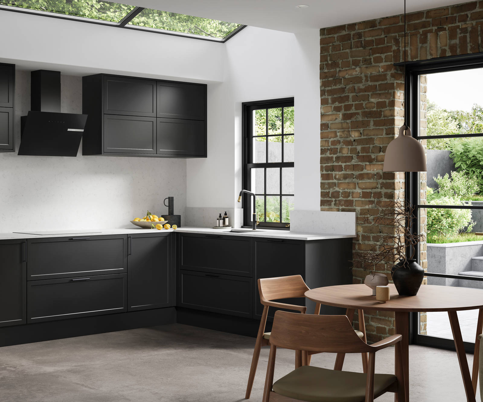 View of modern shaker kitchen Brunswick Sumi Black, with screen extractor over induction hob, black frame skylights with wood dining table and chairs in foreground, combination of white walls and sxposed brick wall.