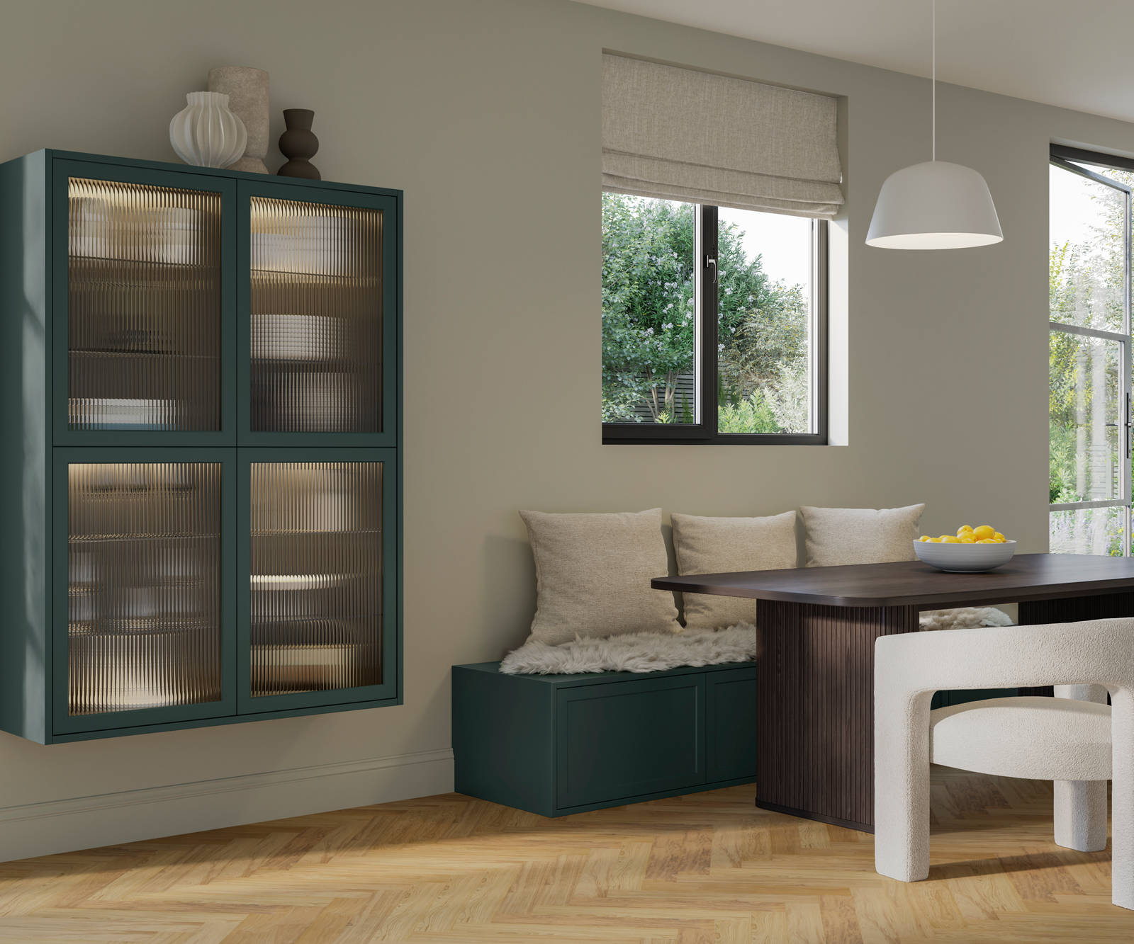 Seating area in muted green modern shaker Brunswick kitchen, a green bench with woft white pillows and wall cabinetry with fluted glass fronts.