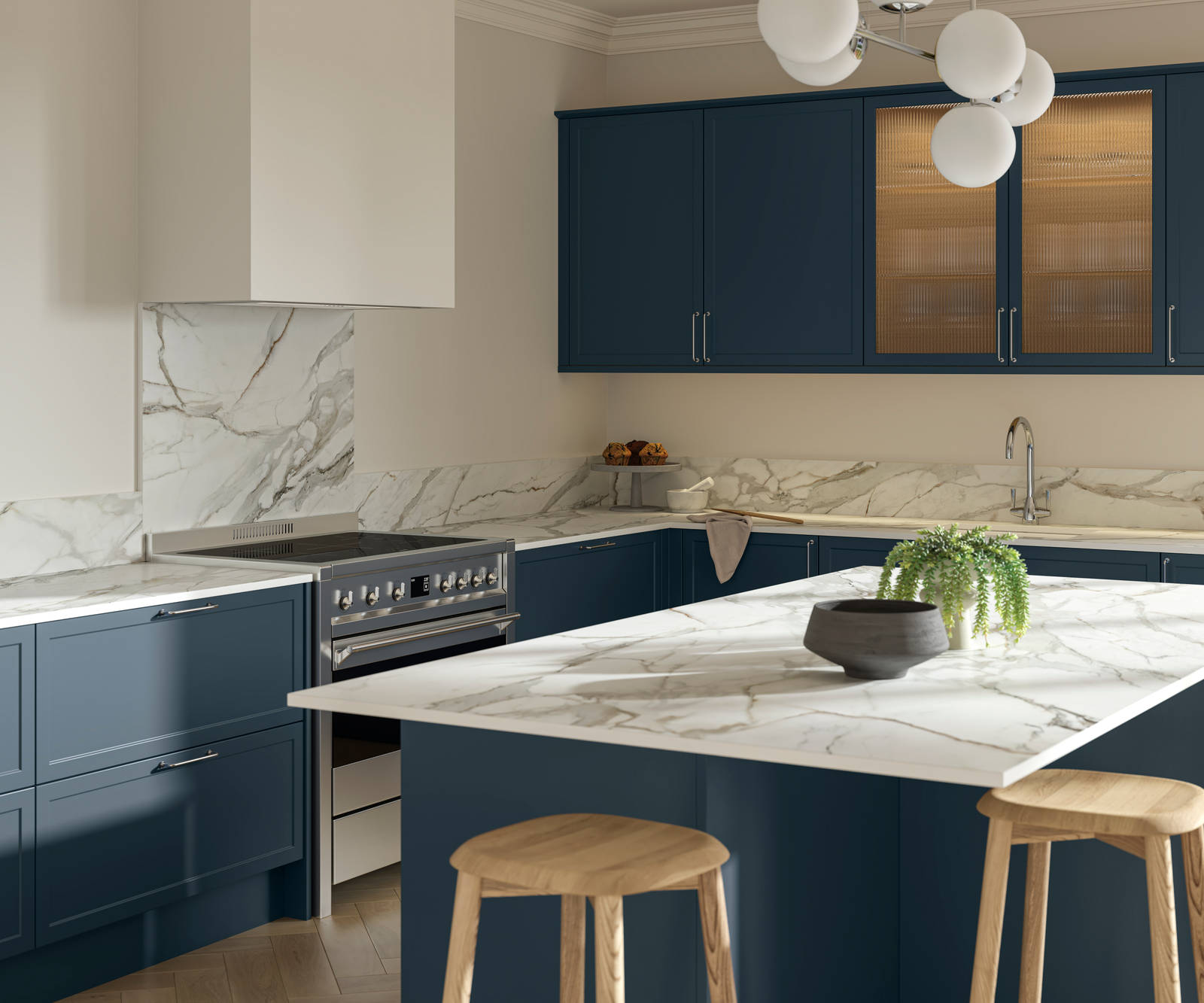 View over kitchen island breakfast bar in modern Shaker kitchen Brunswick Voyage blue with white and grey marbled worktop and matching splashback, and vitrine cabinets with fluted glass.