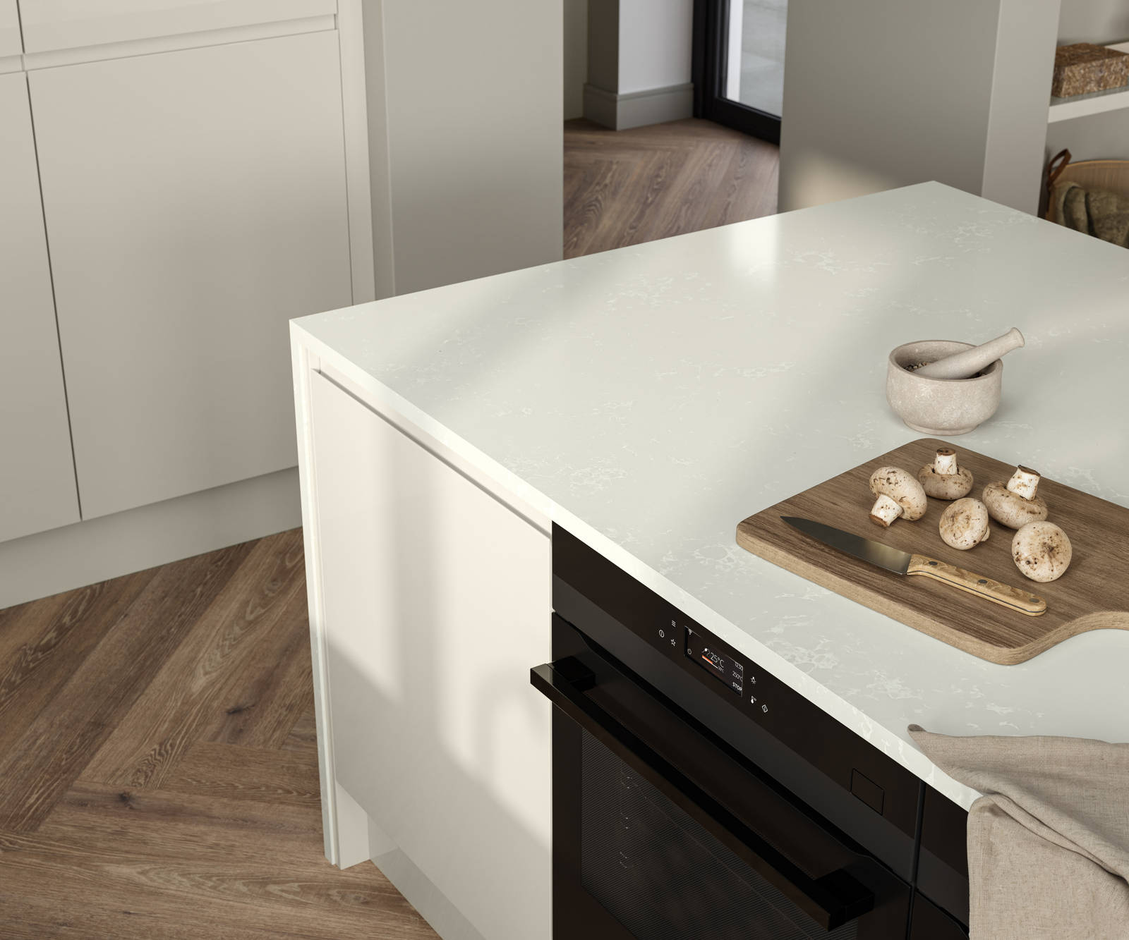 View of wood cutting board and knife with mushrooms on Minerva chalk venato worktop covered contemporary Luna Gloss Limestone kitchen island with integrated oven, Amtico smouldering oak parquet flooring.