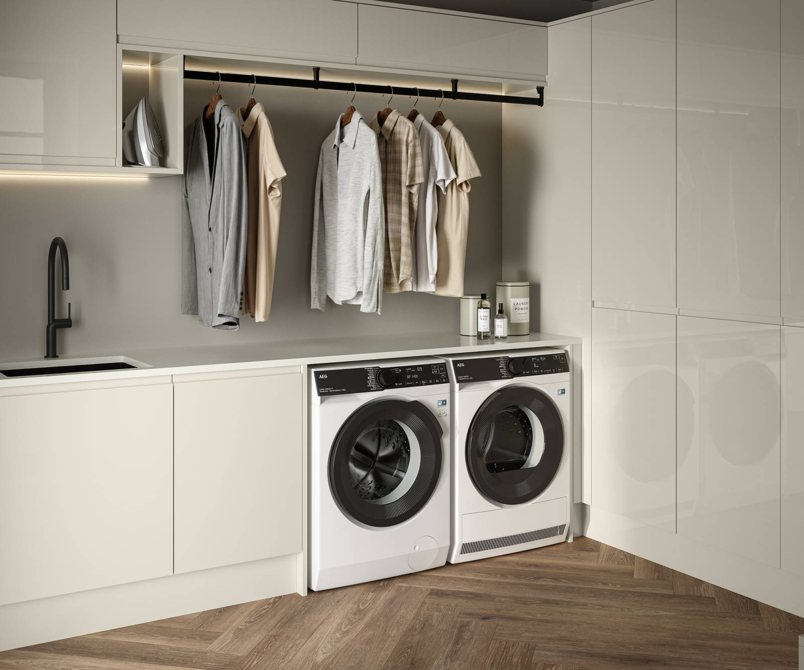 Contemporrary and elegant Luna Gloss Limestone kitchen with integrated washing machine and tumble dryer, tall cabinets, coat hanger under top cabinets and a black sink matched with black tap and Amtico smouldering oak parquet flooring.