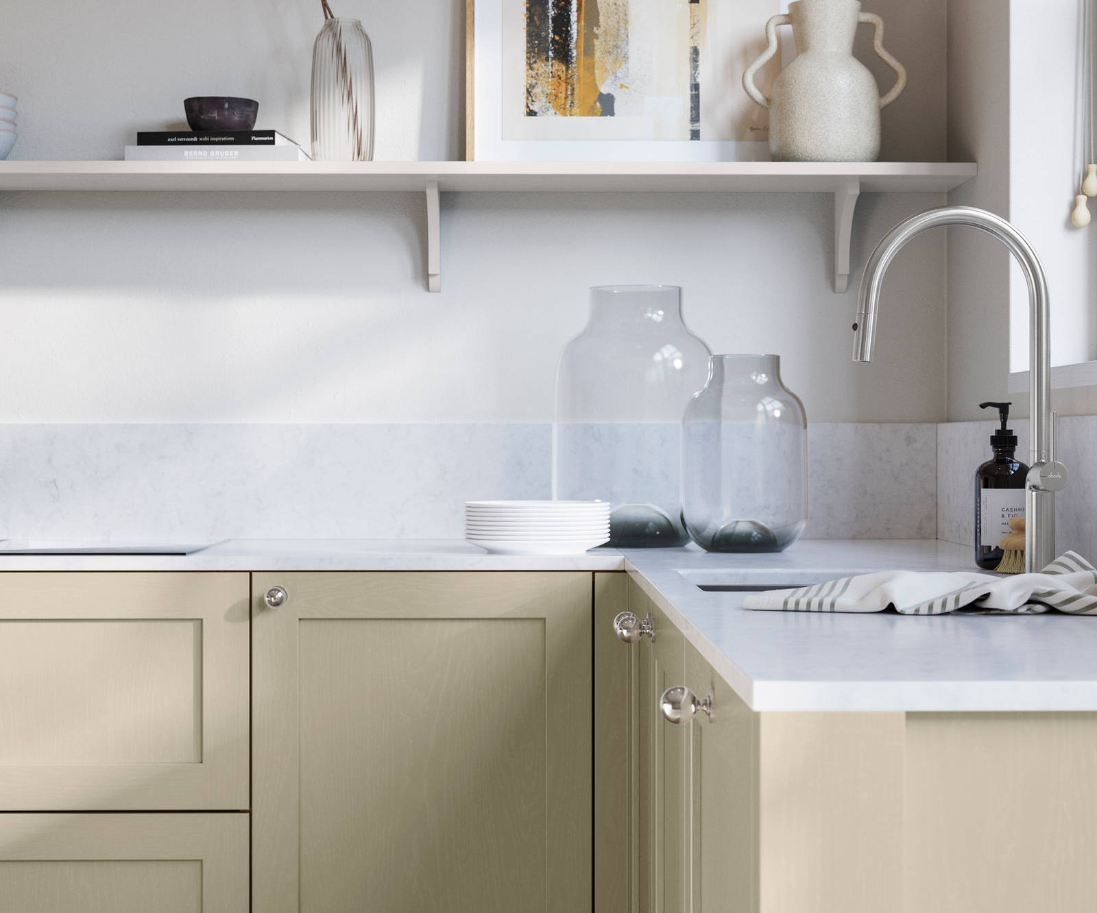 Wardley Parchment kitchen cabinetry with steel knobs, steel tap, white marbled worktop and matching backsplash. An open shelf on the wall above cabinets with ceramics and a vase of flowers.