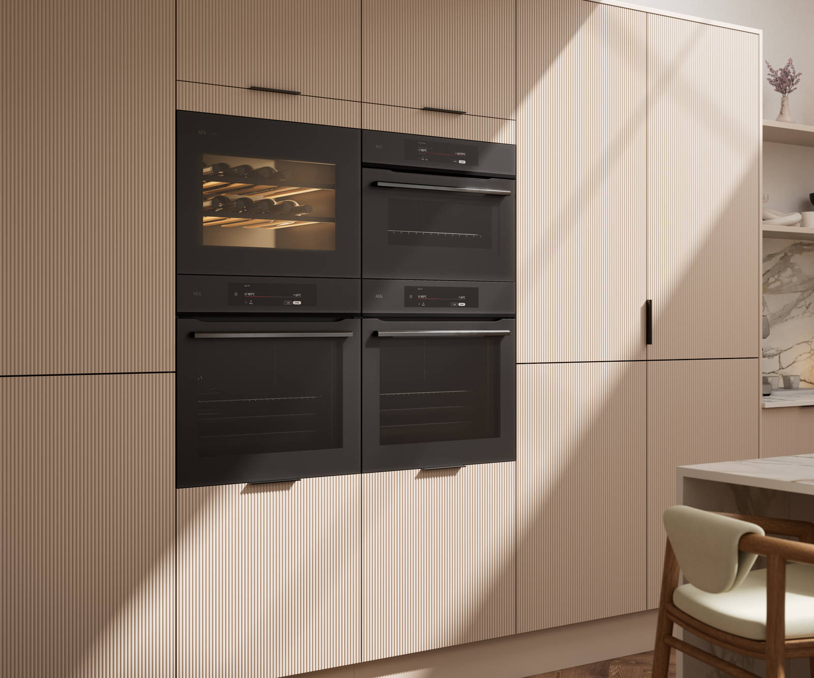 Fluted front kitchen Reed from Magnet in light warm neutral shade Shell, tall cabinets with appliances like ovens and a wine cooler, black handles