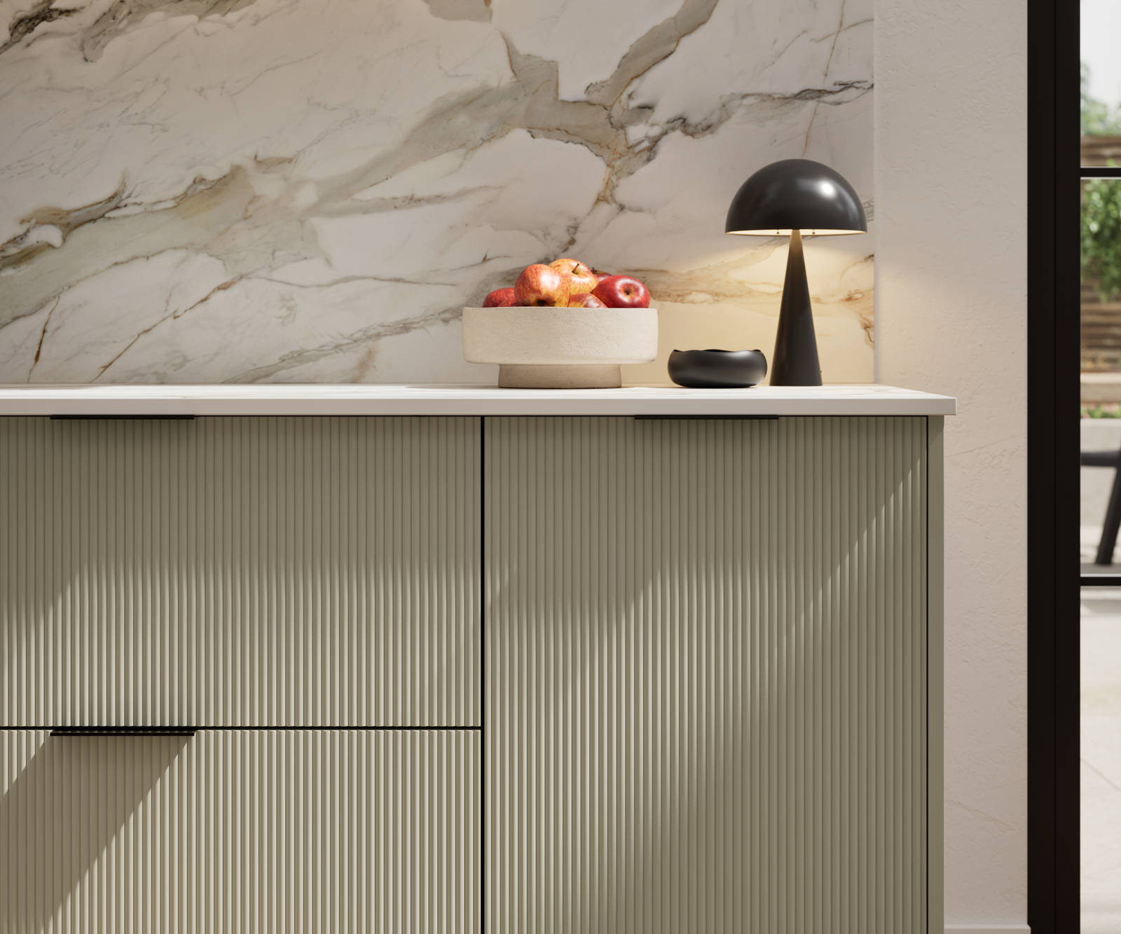 Fluted front kitchen Reed from Magnet in neutral shade French Clay, with a marbled splashback and black handles, herringbone wood flooring.