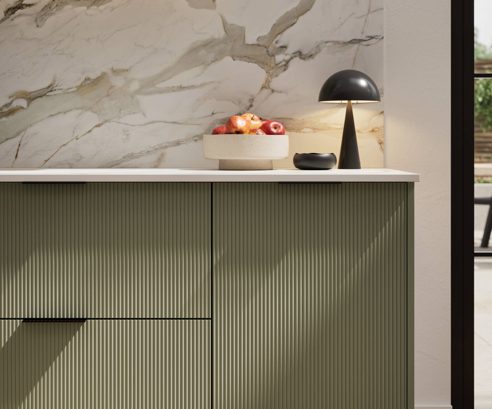 Fluted front kitchen Reed from Magnet in green shade Misty Moors, with a marbled splashback and black handles, herringbone wood flooring.