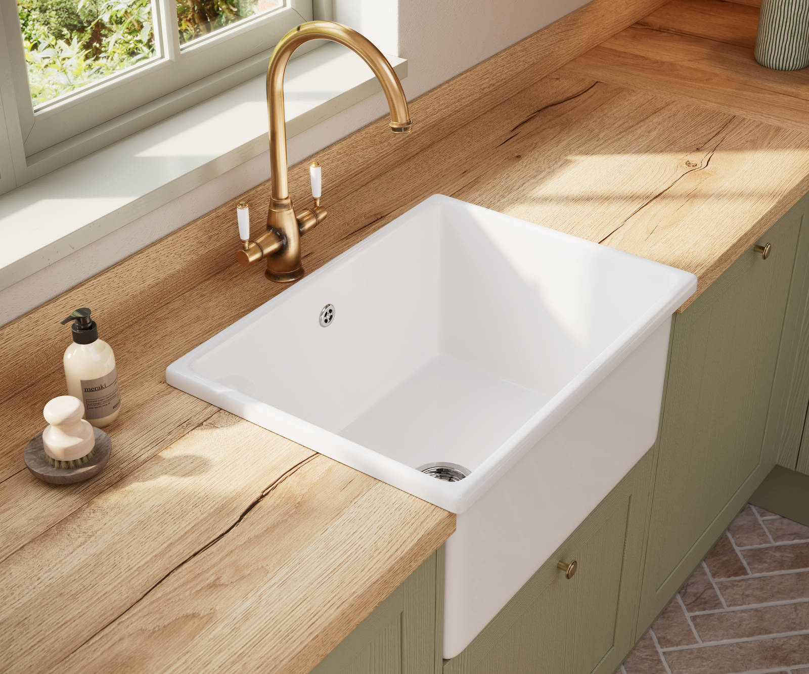White ceramic Belfast sink and traditional style hot water tap in Contemporary Shaker kitchen Ambleside from Magnet in sage green shade Meadow with wooden effect worktop.