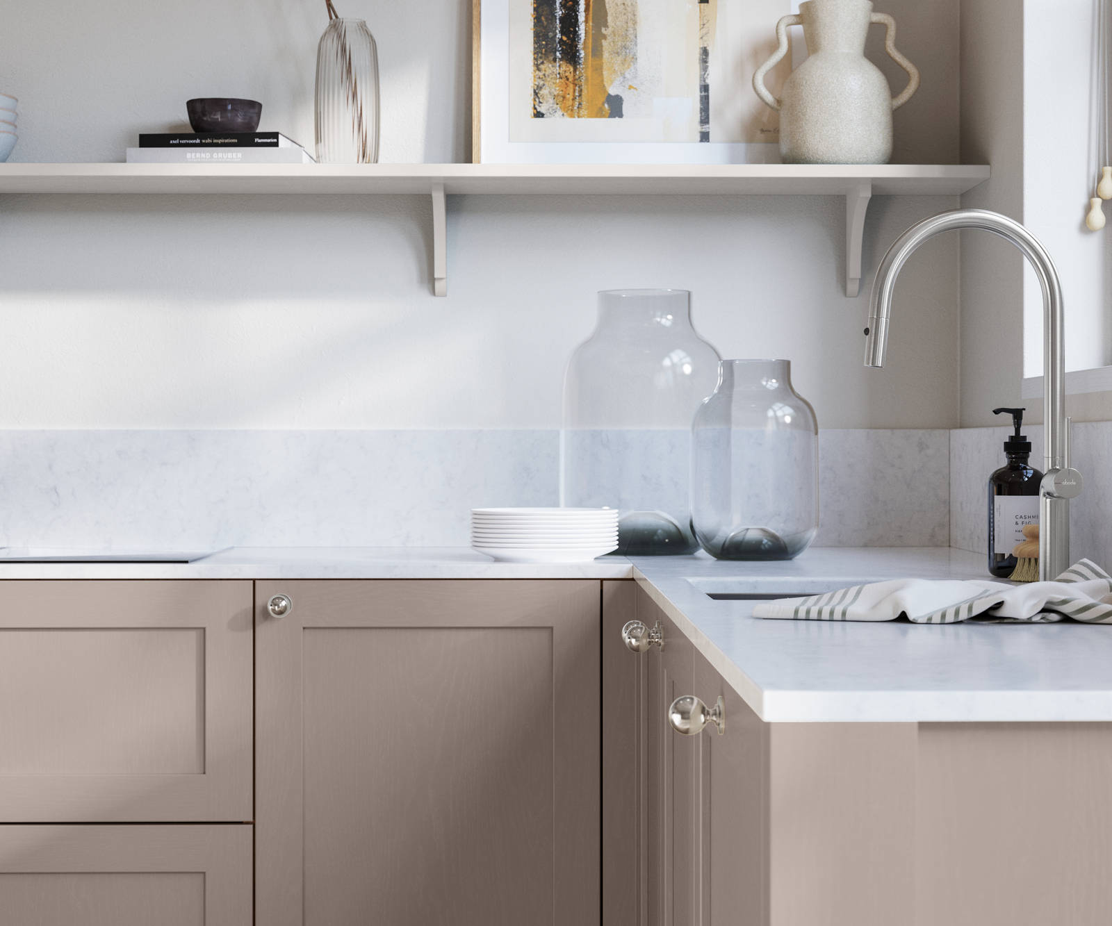 Wardley Cornish Clay kitchen cabinetry with steel knobs, steel tap, white marbled worktop and matching backsplas, an open shelf on the wall above cabinets with ceramics and a vase of flowers.