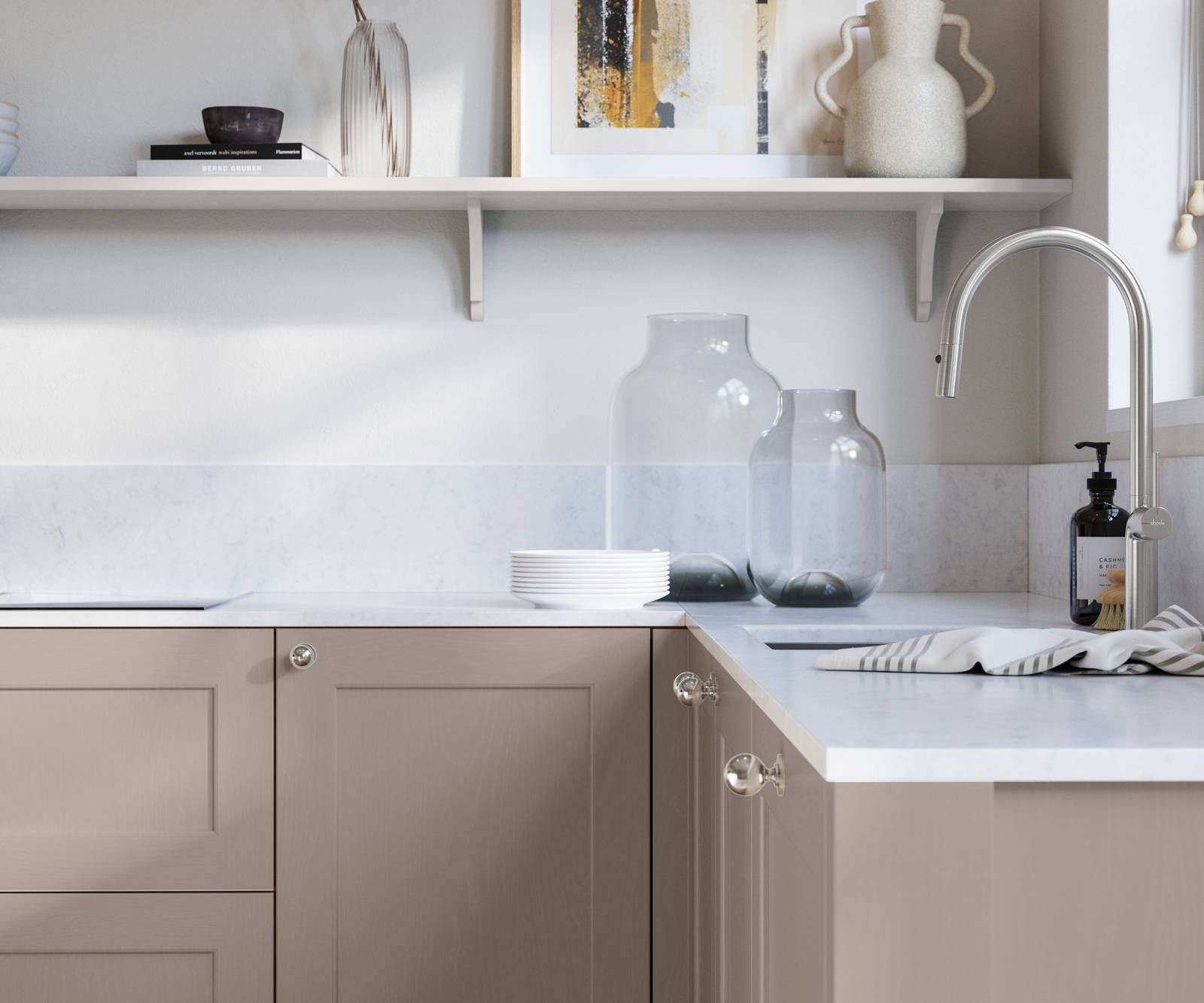 Ludlow, a traditional Shaker-style premium feel kitchen range with a visible woodgrain on its panelled doors here shown in the shade Cornish Clay styled with steel knobs, steel tap, a white marbled worktop with matching splashback.