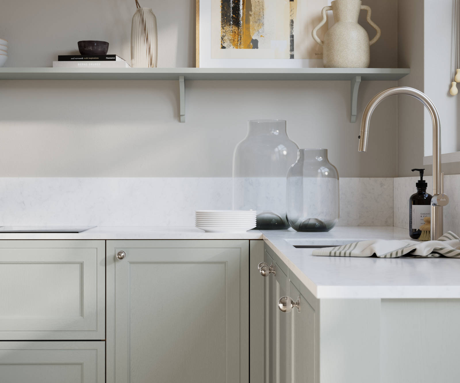 Bewdley Washed Cotton painted wood grain Shaker kitchen cabinetry with steel knobs, steel tap, white marbled worktop and matching backsplash, an open shelf on the wall above cabinets with ceramics and a vase of flowers.