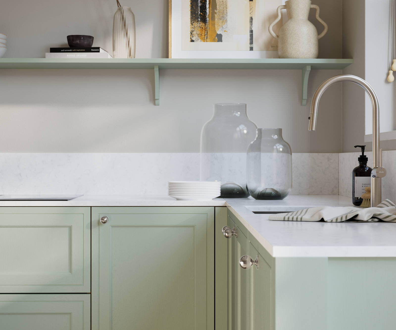 Bewdley Seagrass painted wood grain Shaker kitchen cabinetry with steel knobs, steel tap, white marbled worktop and matching backsplash, an open shelf on the wall above cabinets with ceramics and a vase of flowers.