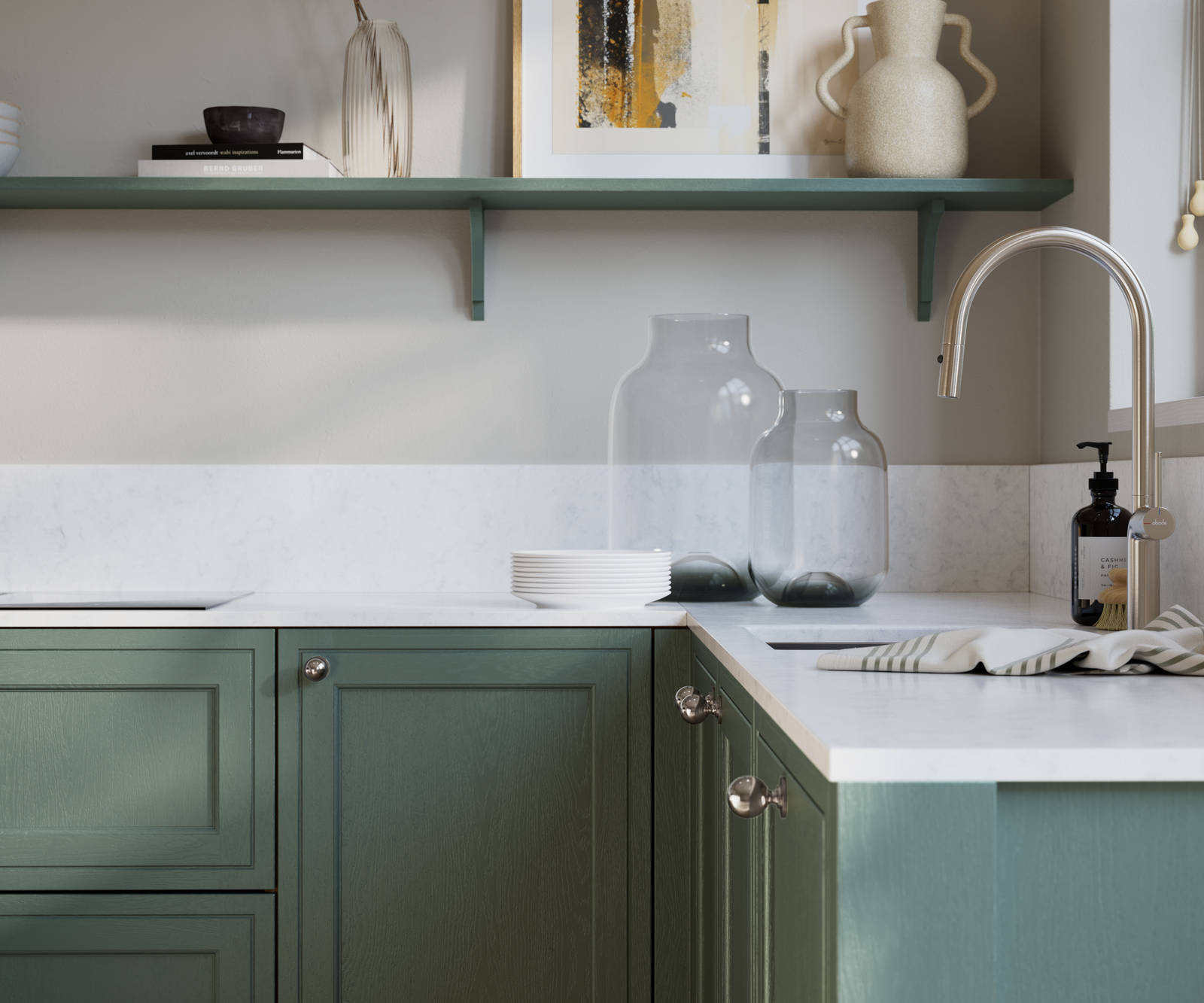 Bewdley Eucalyptus Green painted wood grain Shaker kitchen cabinetry with steel knobs, steel tap, white marbled worktop and matching backsplash, an open shelf on the wall above cabinets with ceramics and a vase of flowers.
