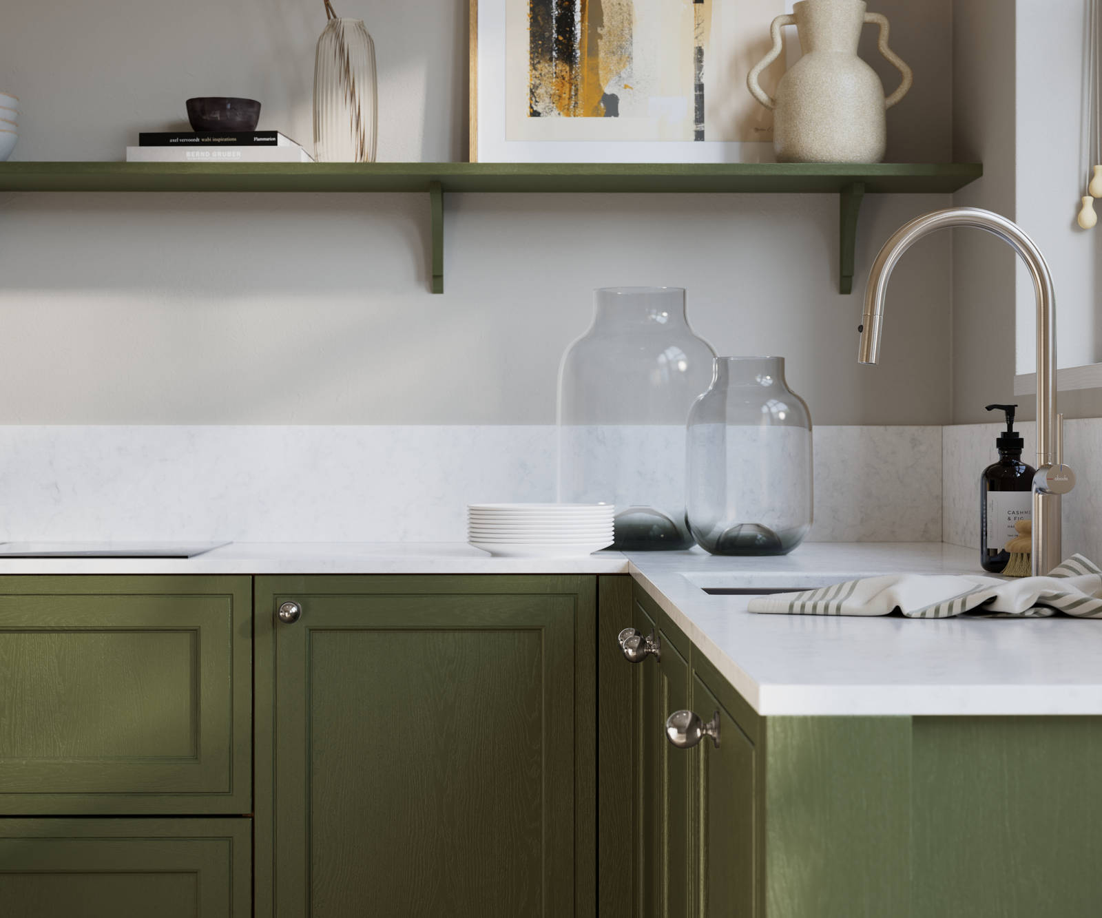 Bewdley Tailored Green painted wood grain Shaker kitchen cabinetry with steel knobs, steel tap, white marbled worktop and matching backsplash, an open shelf on the wall above cabinets with ceramics and a vase of flowers.
