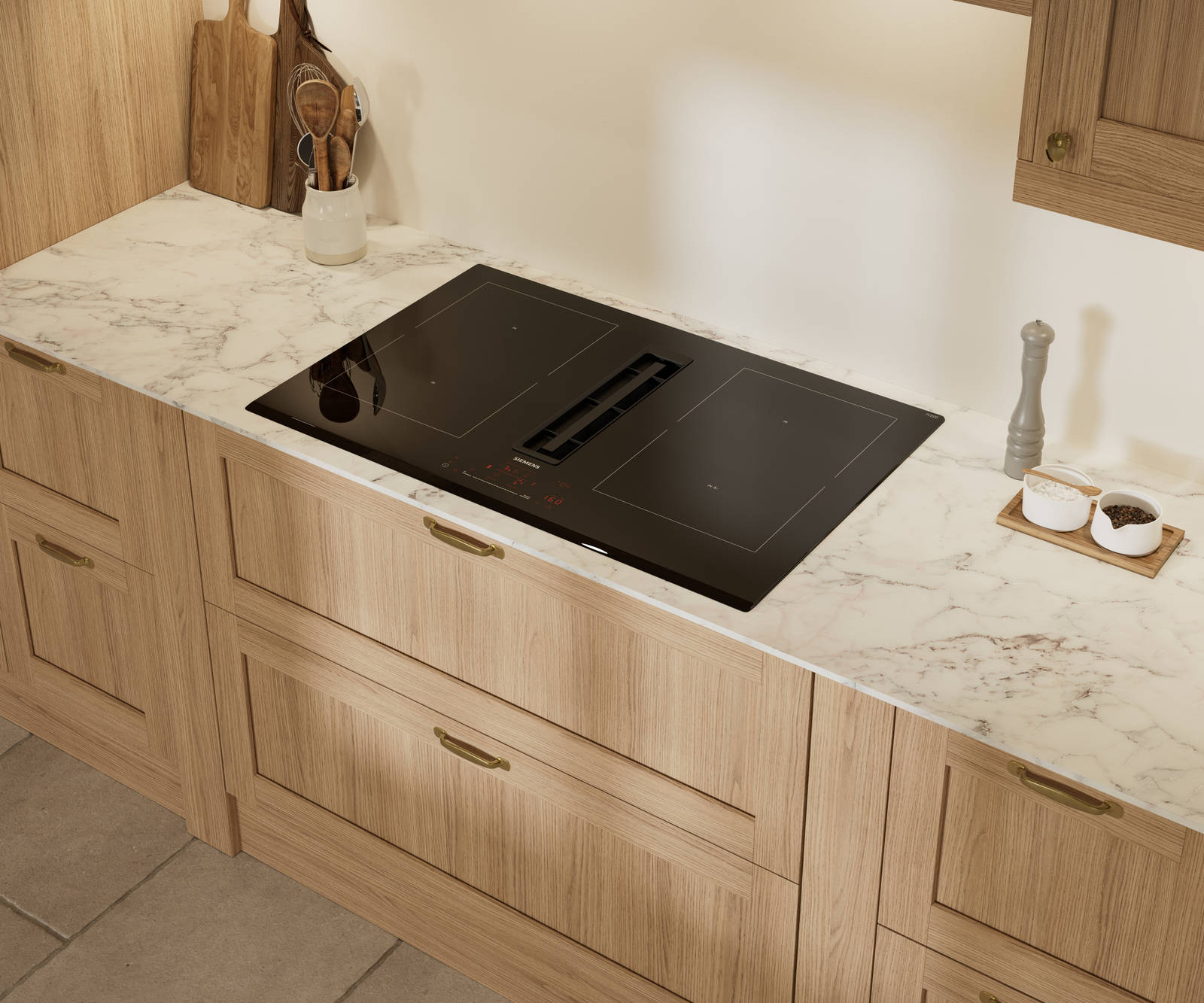 View of vented hob and marbled worktop in Traditional premium contemporary Shaker kitchen Ambleside in oak with brass knobs and handles.