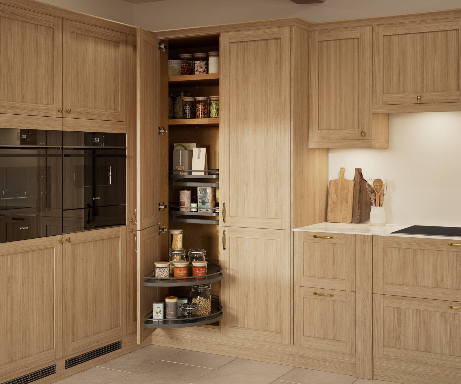 Traditional premium contemporary Shaker kitchen Ambleside in oak with brass knobs and handles, built-in ovens in tall cabinetry, opened tall corner cabinet with oak shelves and pull-out carousel.