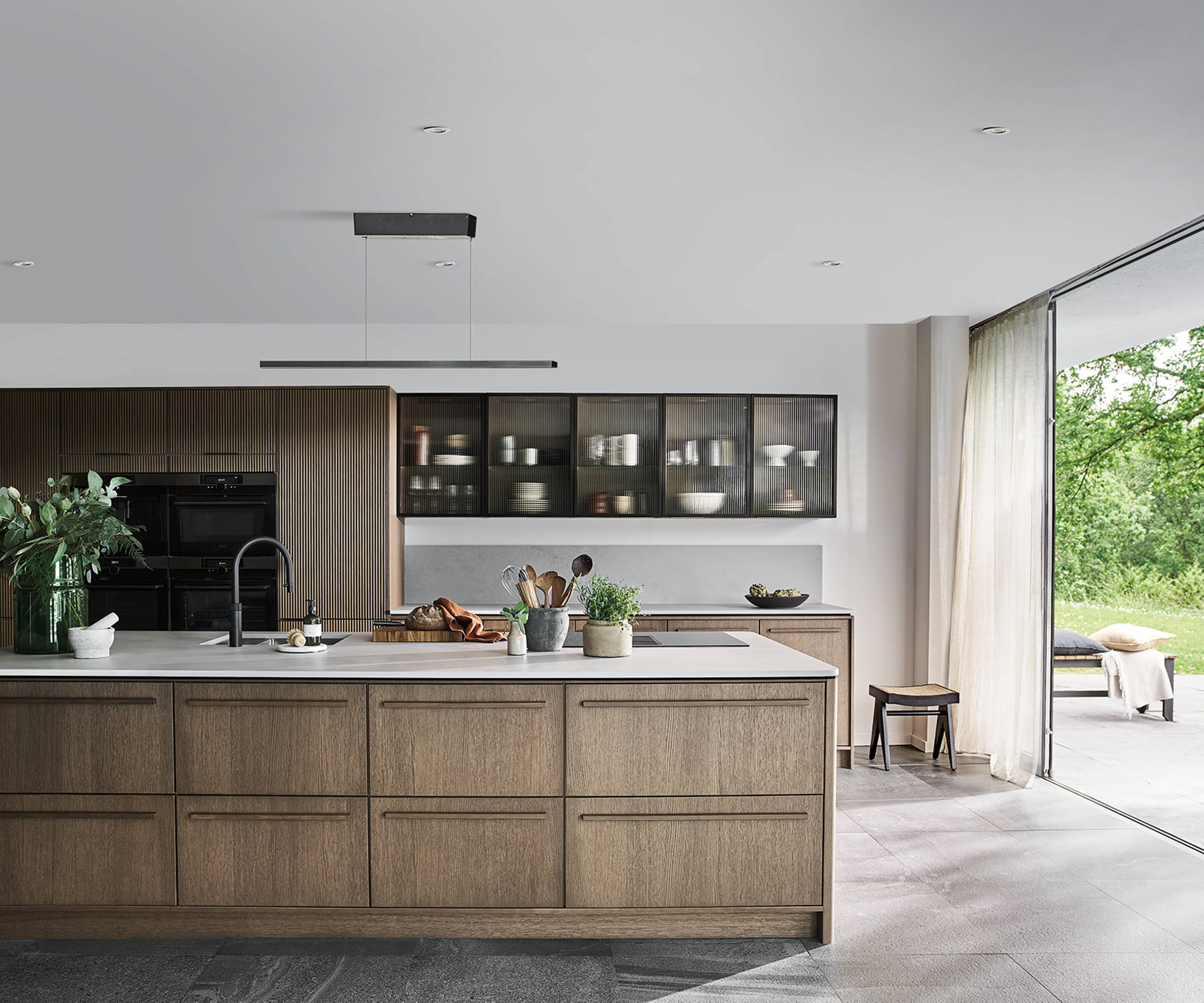 Magnet Kitchens 2021 Nordic Nature range with Fluted oak cabinets with Dekton Aeri worktop. Floating island with boiling hot water tap.