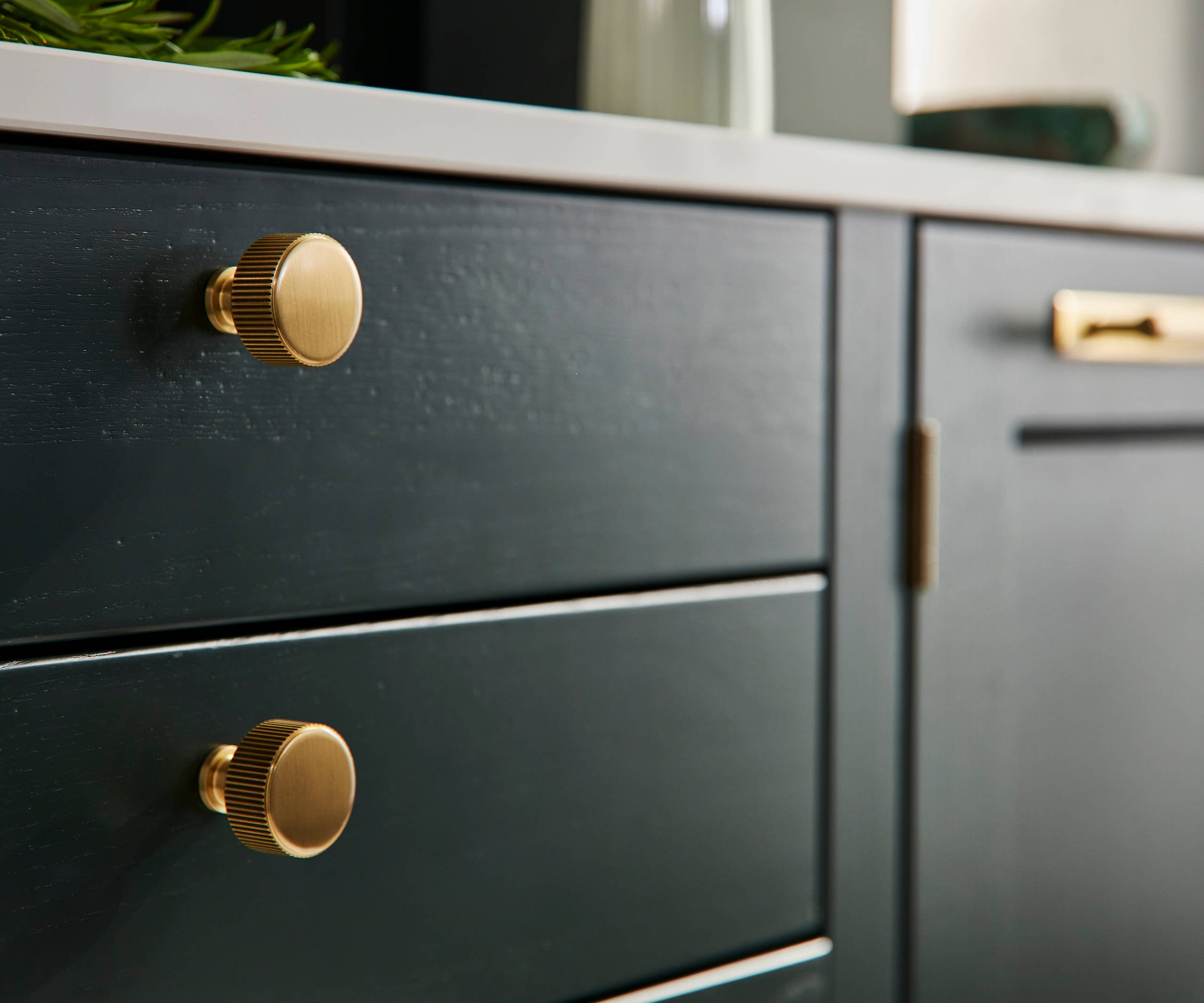 Ludlow, a traditional Shaker-style kitchen range in the shade Arboretum Green, combined with brass handles and knobs.