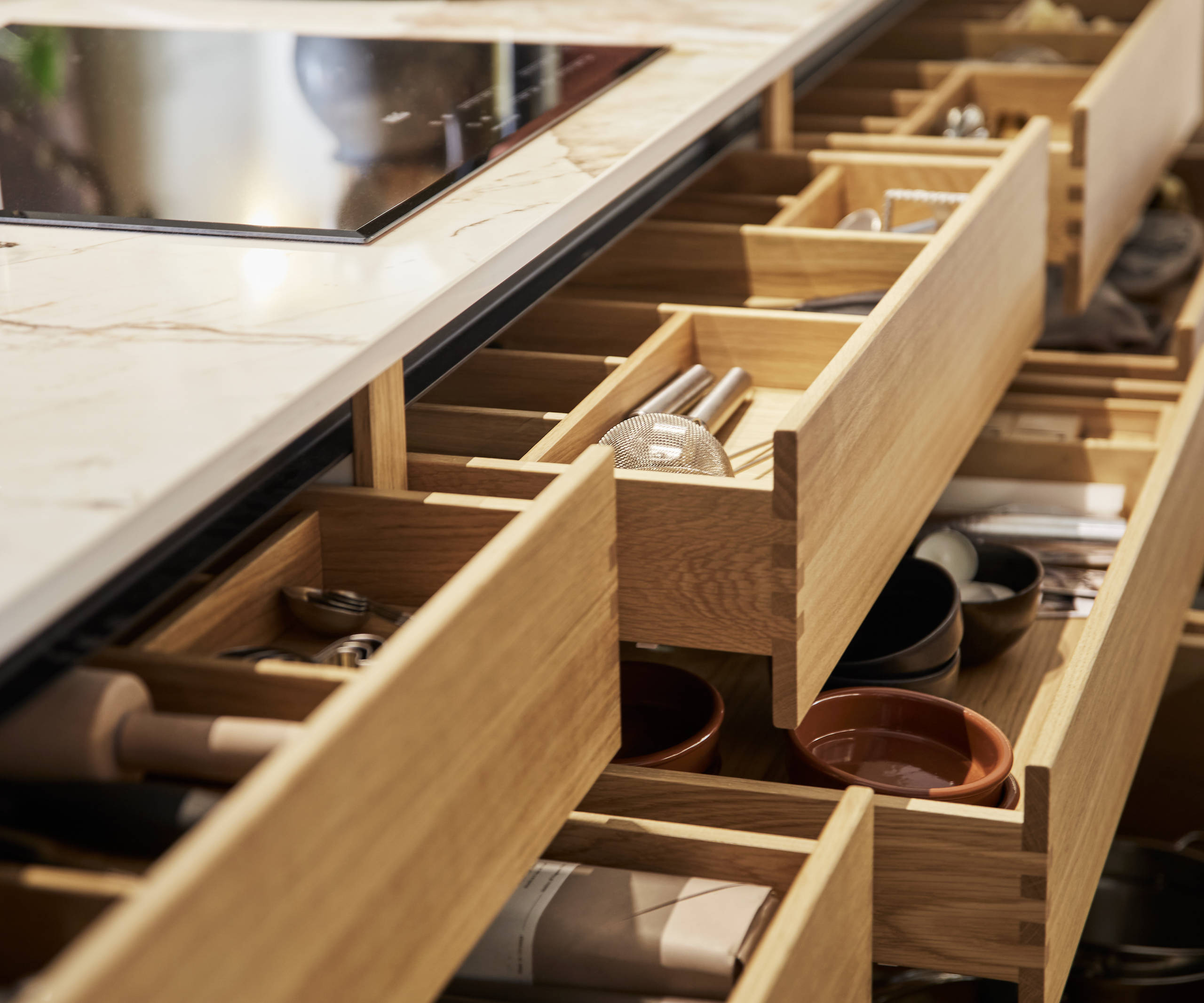 Full view of oak inserts in opened oak drawers in the Nordic Craft kitchen island.