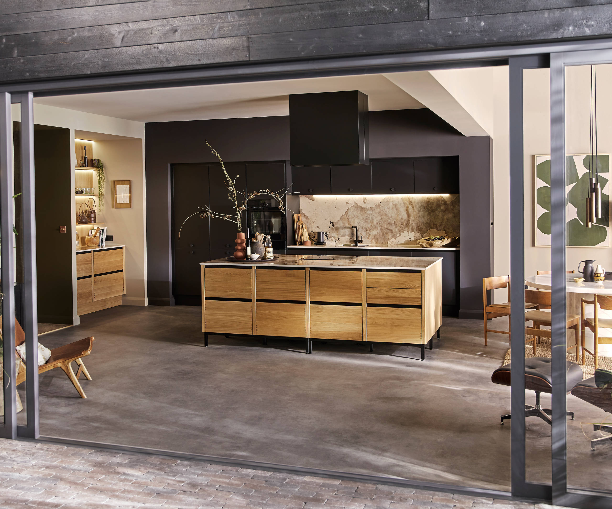 View of the Mindful World kitchen concept through opened glass doors to a patio.