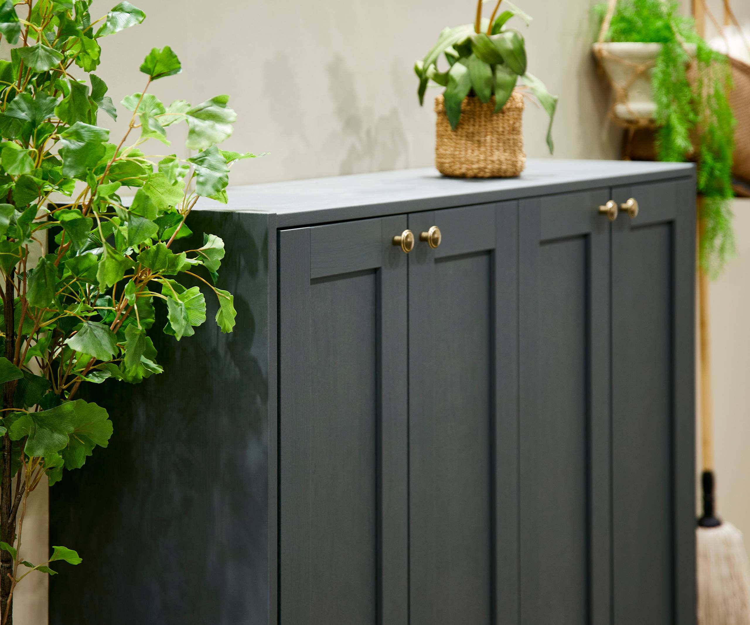 The Ambleside kitchen range in Fern, a dark shade of green, paired with brass handles.
