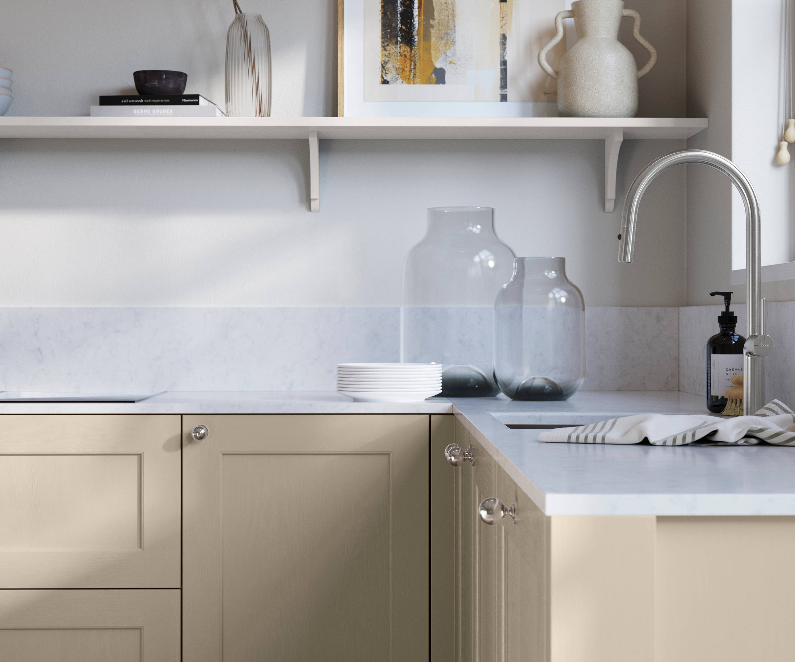 Ludlow, a traditional Shaker-style premium feel kitchen range with a visible woodgrain on its panelled doors here shown in the neutral shade Pebble path styled with steel knobs, steel tap, a white marbled worktop with matching splashback.