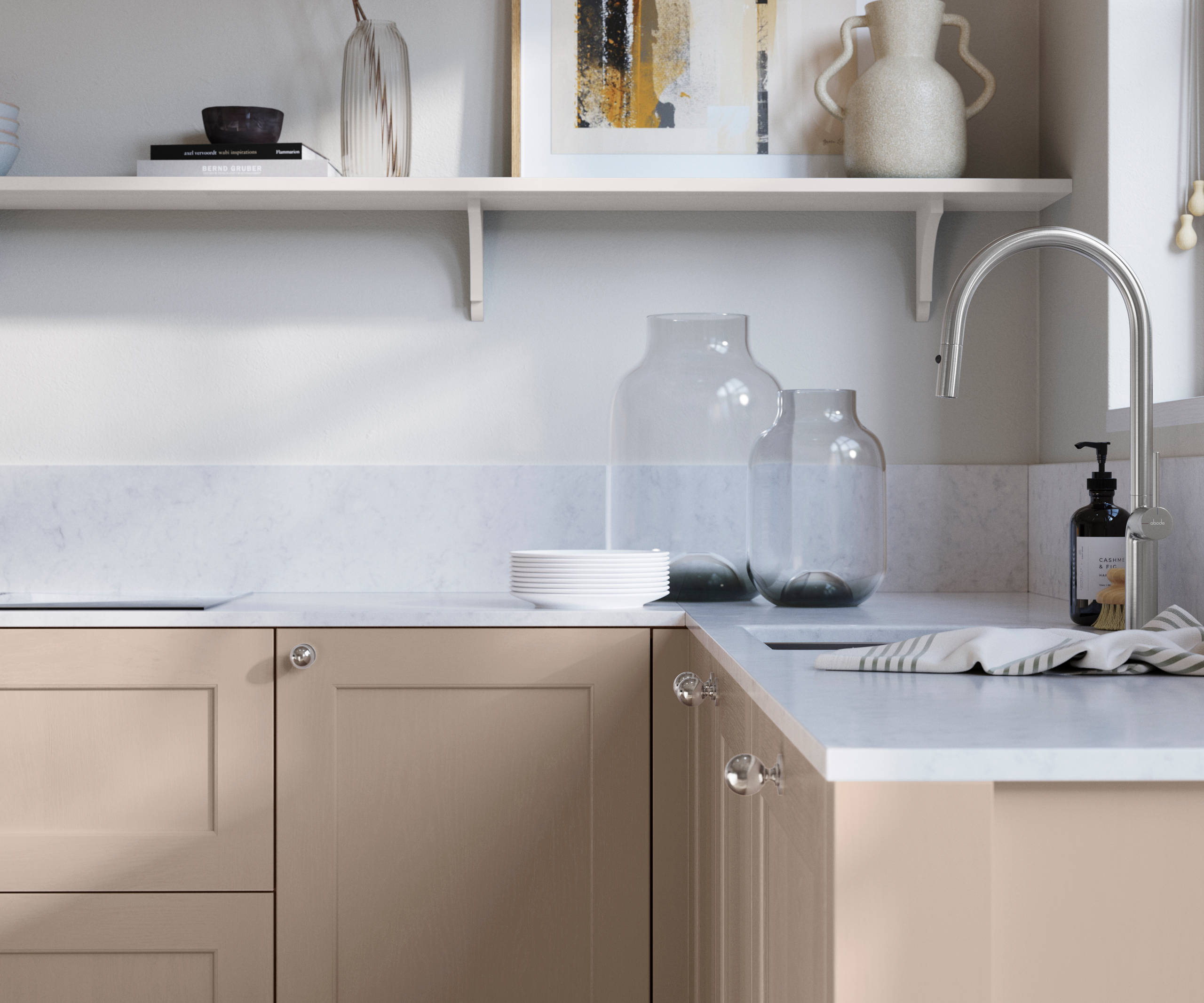 Ludlow, a traditional Shaker-style premium feel kitchen range with a visible woodgrain on its panelled doors here shown in the light shade Shell styled with steel knobs, steel tap, a white marbled worktop with matching splashback.