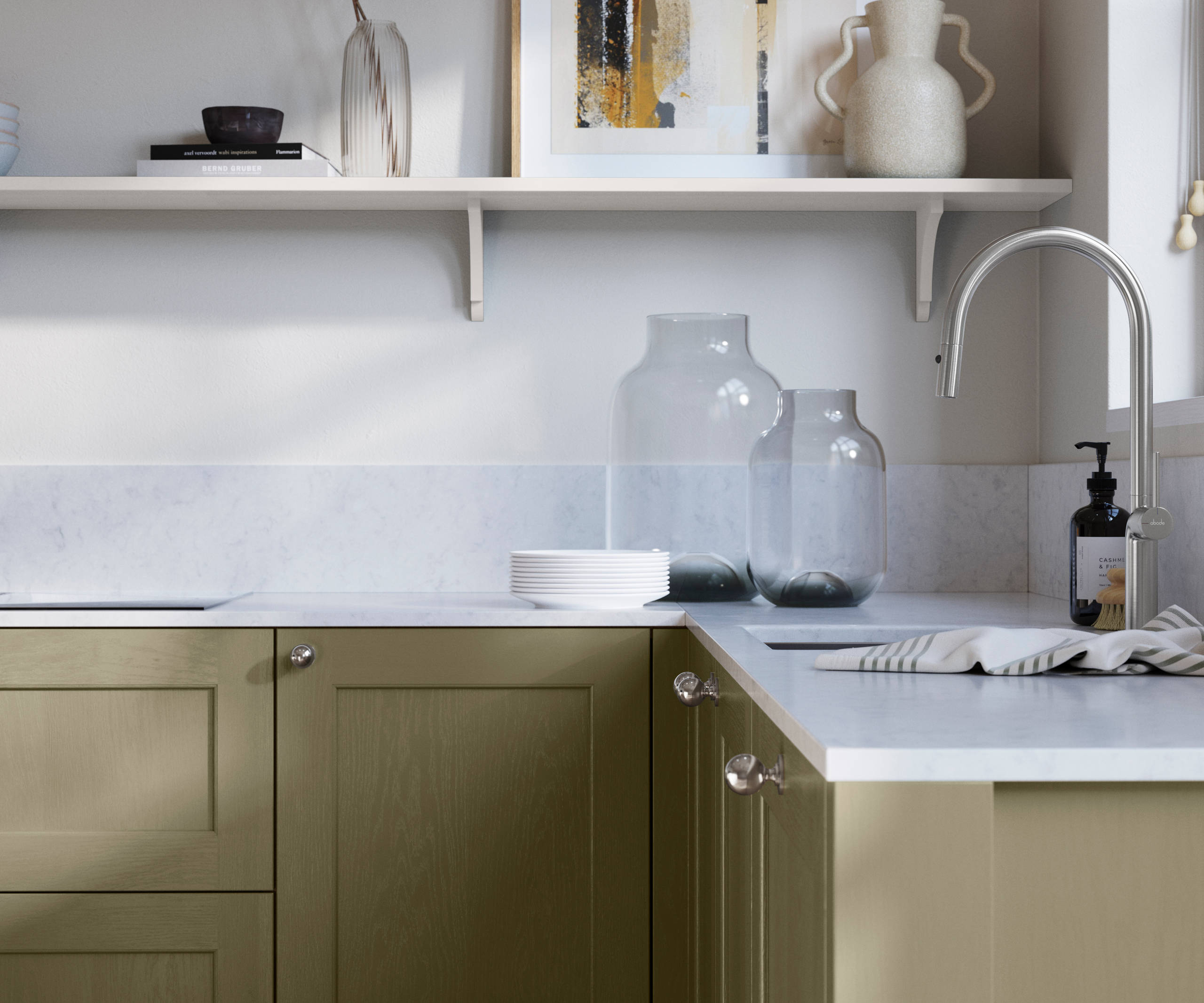 Ludlow, a traditional Shaker-style premium feel kitchen range with a visible woodgrain on its panelled doors here shown in the green shade Balmoral styled with steel knobs, steel tap, a white marbled worktop with matching splashback.